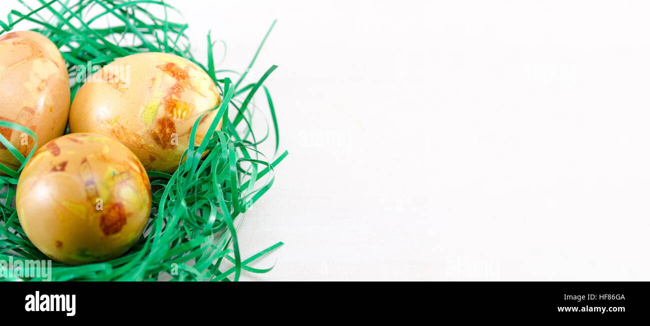 Painted Easter eggs in green straw on a table Stock Photo