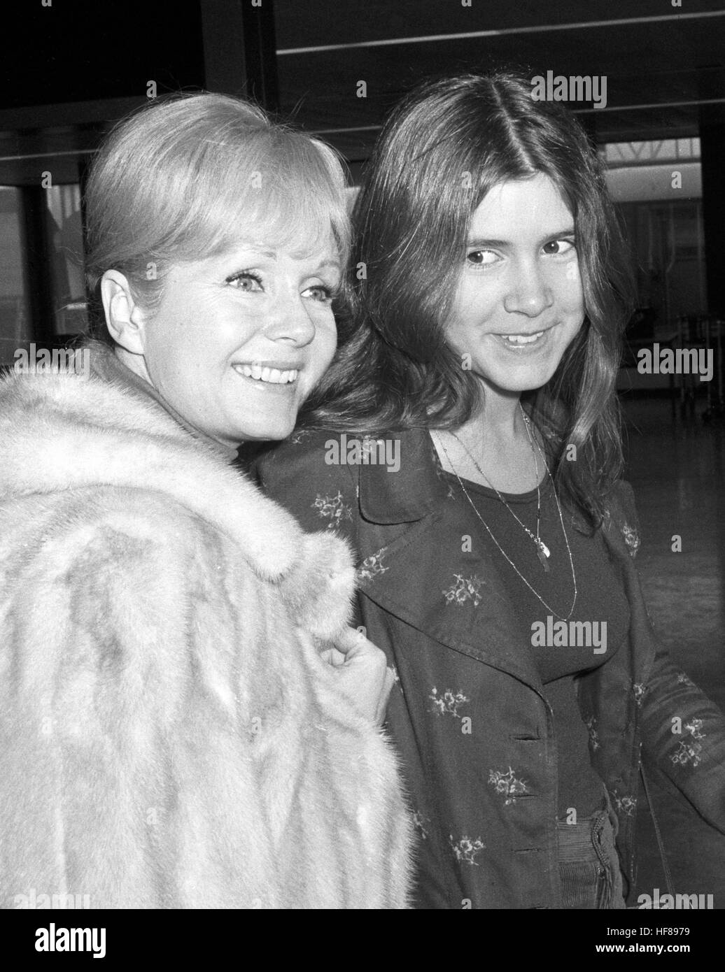 Actress Debbie Reynolds (l) and her daughter Carrie Fisher, 15, are en route to Madrid at Heathrow Airport in London. Stock Photo