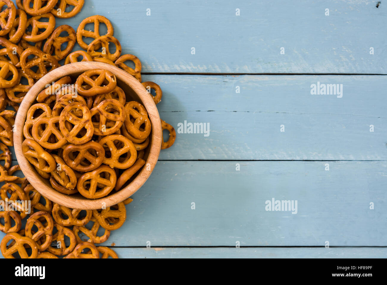 Salted pretzel in bowl on blue wooden background Stock Photo