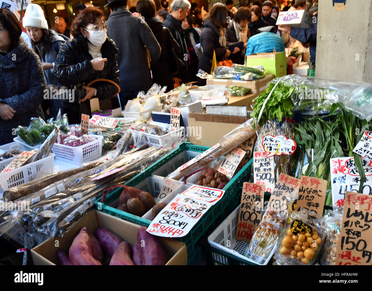 Tokyo, Japan. 28th Dec, 2016. A flock of bargain-hunters and some foreign tourists throngs the narrow maze of alleys lined with hundreds of small shops and stalls selling fresh fish and marine products outside of Tokyo's main fish market in Tsukiji on Wednesday, December 28, 2016, the customary last business day of the year. The planned move of the nation's largest wholesale market to the neighboring Toyosu district still hangs in limbo over soil pollution fears and bickering between those for and against the change. © Natsuki Sakai/AFLO/Alamy Live News Stock Photo