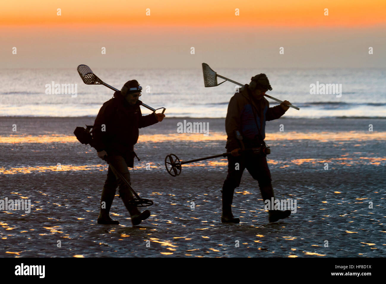 Blackpool, UK. 28th Dec 2016. Two men metal detectorists, silhouetted