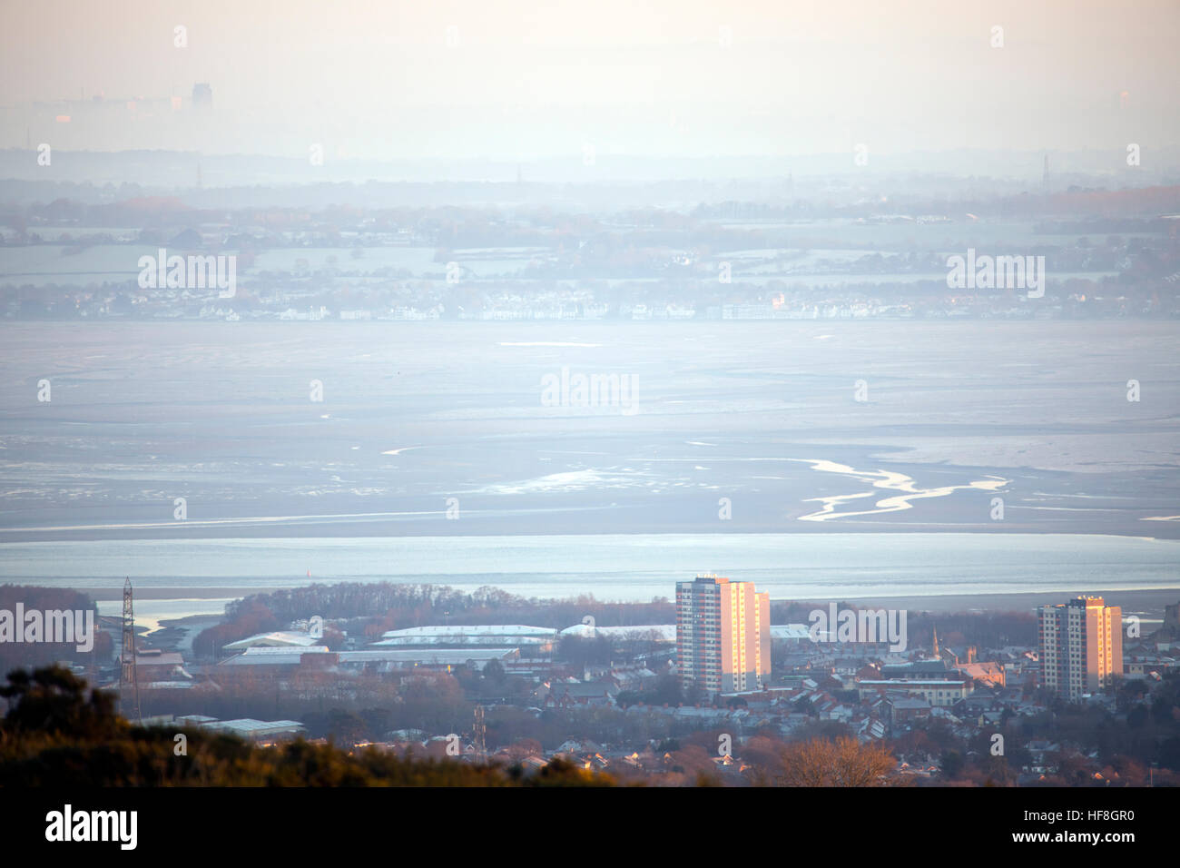 Frosty foggy conditions over Flint in Flintshire across the River Dee and River Mersey with the Roman Cathedral in Liverpool in the distance Stock Photo