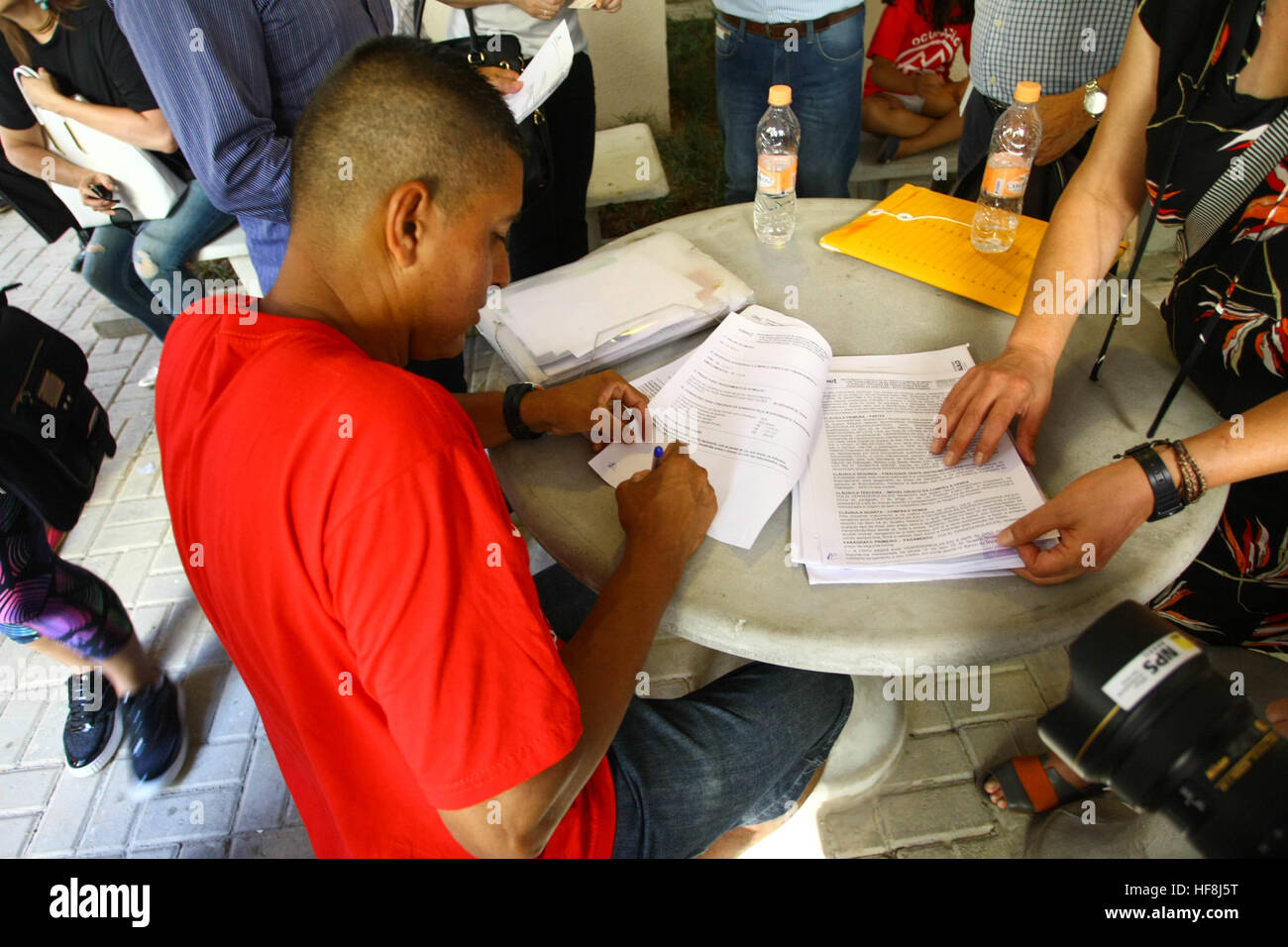 SÃO PAULO, SP - 29.12.2016: ENTREGA DE APARTAMENTOS DA PRIMEIRA PPP - Pictured resident signs the apartment purchase contract. Governor Geraldo Alckmin delivered on the morning of Thursday (29), at Rua São Caetano in downtown São Paulo, 126 apartments of the first Public-Private Partnership (PPP) in the country housing for low-income families. They attended the event Mayor Fernando Haddad and the mayor elected John Doria. (Photo: Aloisio Mauricio/Fotoarena) Stock Photo