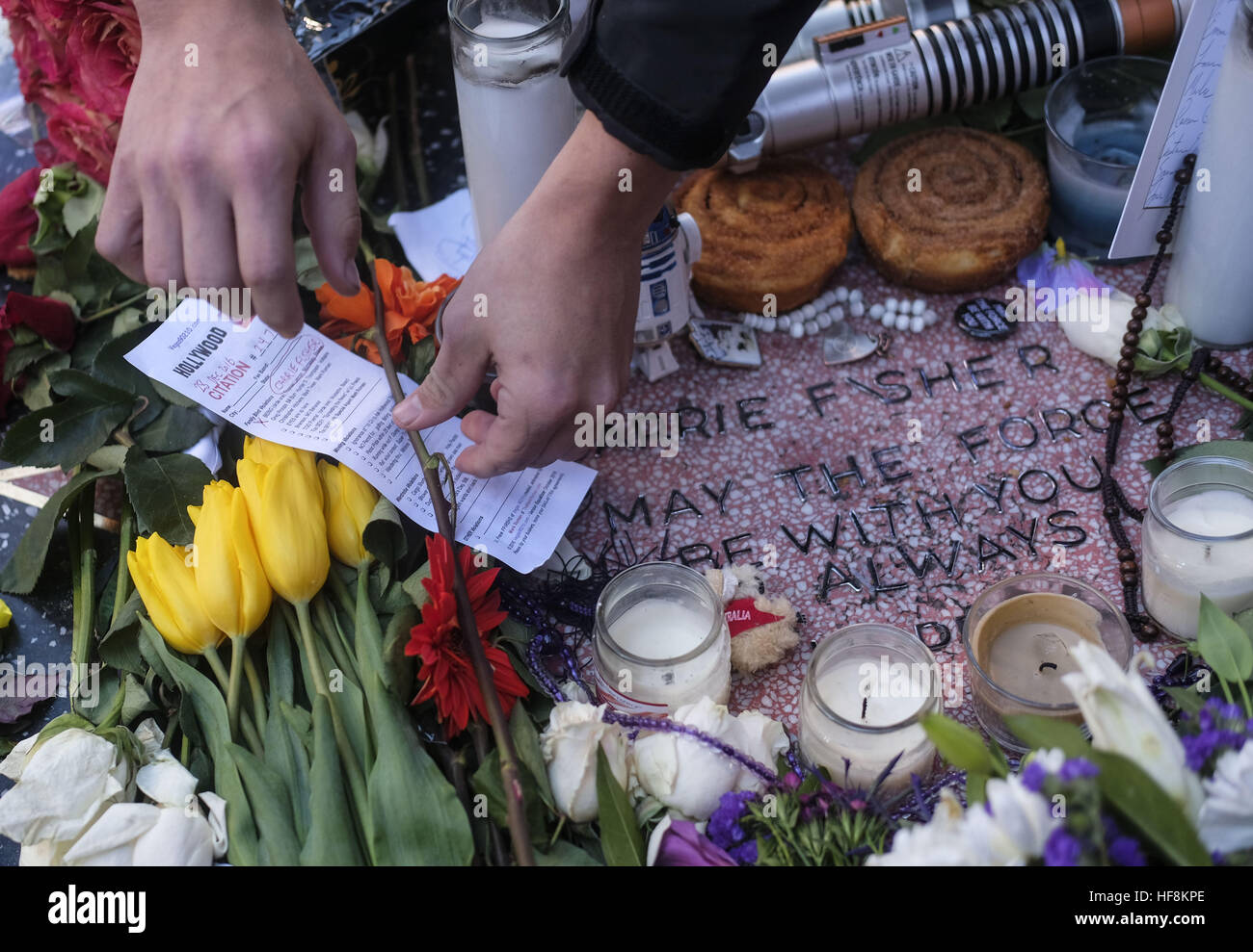 Los Angeles, California, USA. 29th Dec, 2016. An impromptu memorial to actress and author Carrie Fisher with flowers, candles and messages is seen on the sidewalk one block away from the official star of her mother, actress and singer Debbie Reynolds in Los Angeles on Thursday, Dec. 29, 2016. Reynolds, 84, and Fisher, 60, died a day apart, Reynolds on Wednesday, Fisher on Tuesday. Fisher does not have an official Hollywood Walk of Fame star. © Ringo Chiu/ZUMA Wire/Alamy Live News Stock Photo