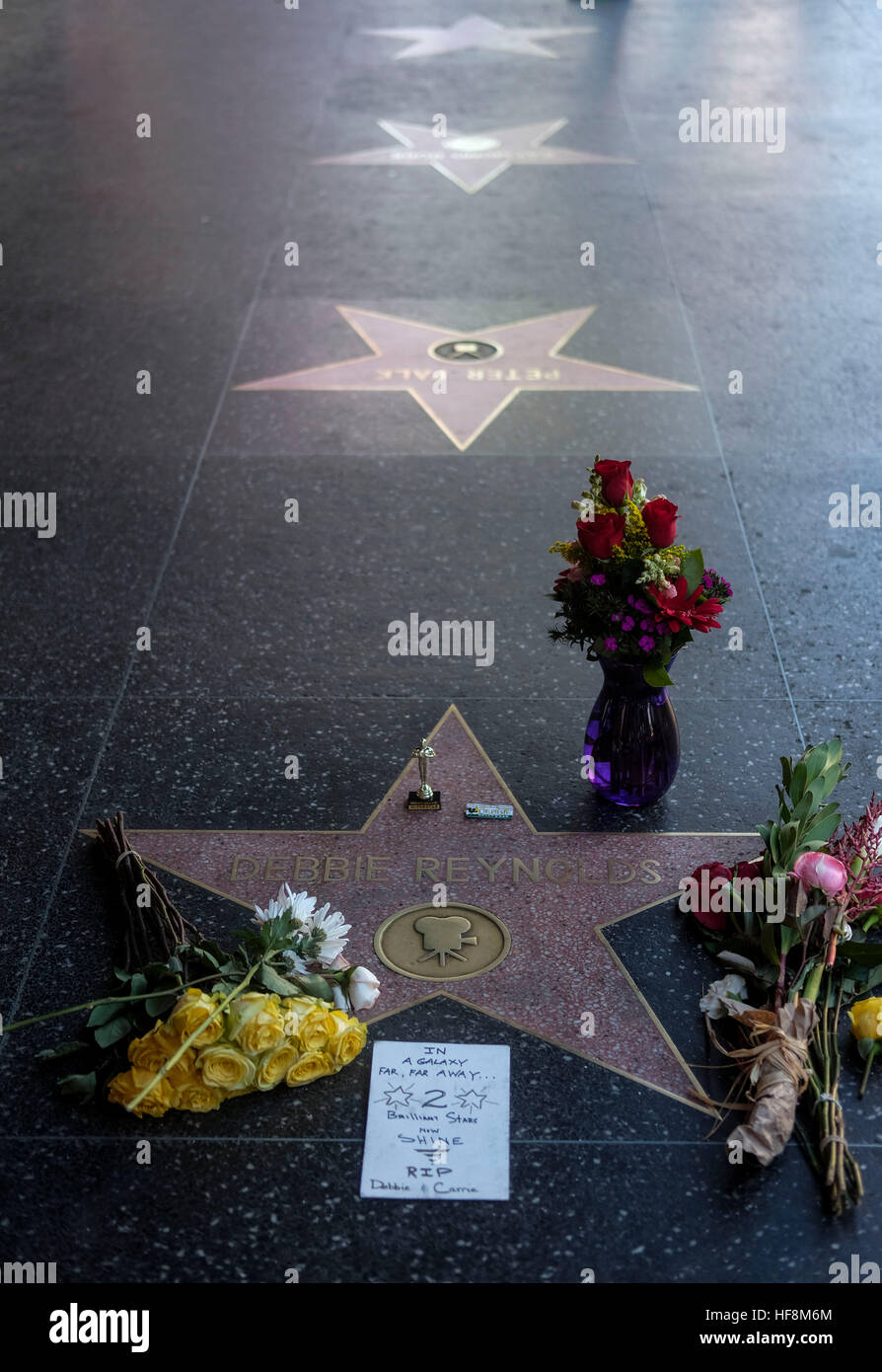 Los Angeles, USA. 29th Dec, 2016. Flowers and candles surround the Hollywood Walk of Fame star of Debbie Reynolds, in Los Angeles, California, the United States, on Dec. 29, 2016. Hollywood star Debbie Reynolds died of stroke Wednesday at the age of 84, one day after her daughter Carrie Fisher's death. Carrie Fisher, the actress best known as Princess Leia in the 'Star Wars' movie franchise, died at the age of 60 on Tuesday morning, after suffering a heart attack on a flight last Friday. © Zhao Hanrong/Xinhua/Alamy Live News Stock Photo