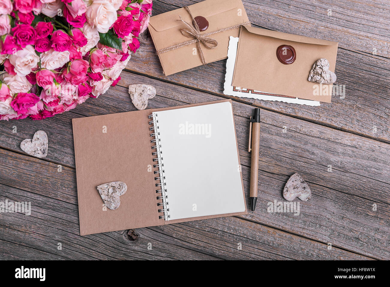 Notebook and roses on a wooden background. Stock Photo