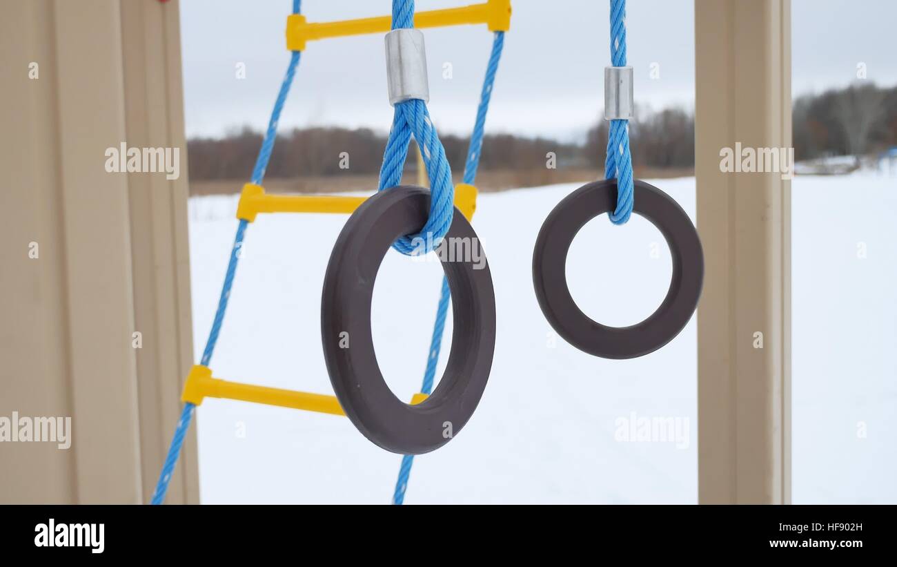 Kids Using Playground Rings children playground gymnastic rings swing, snow winter landscape a ...