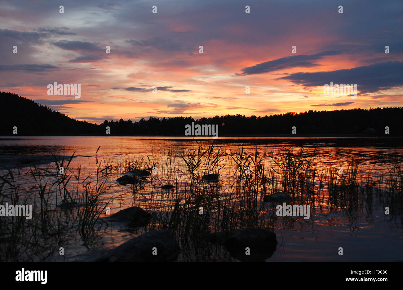 Lake with orange sunset cloudy sky reflection Stock Photo - Alamy