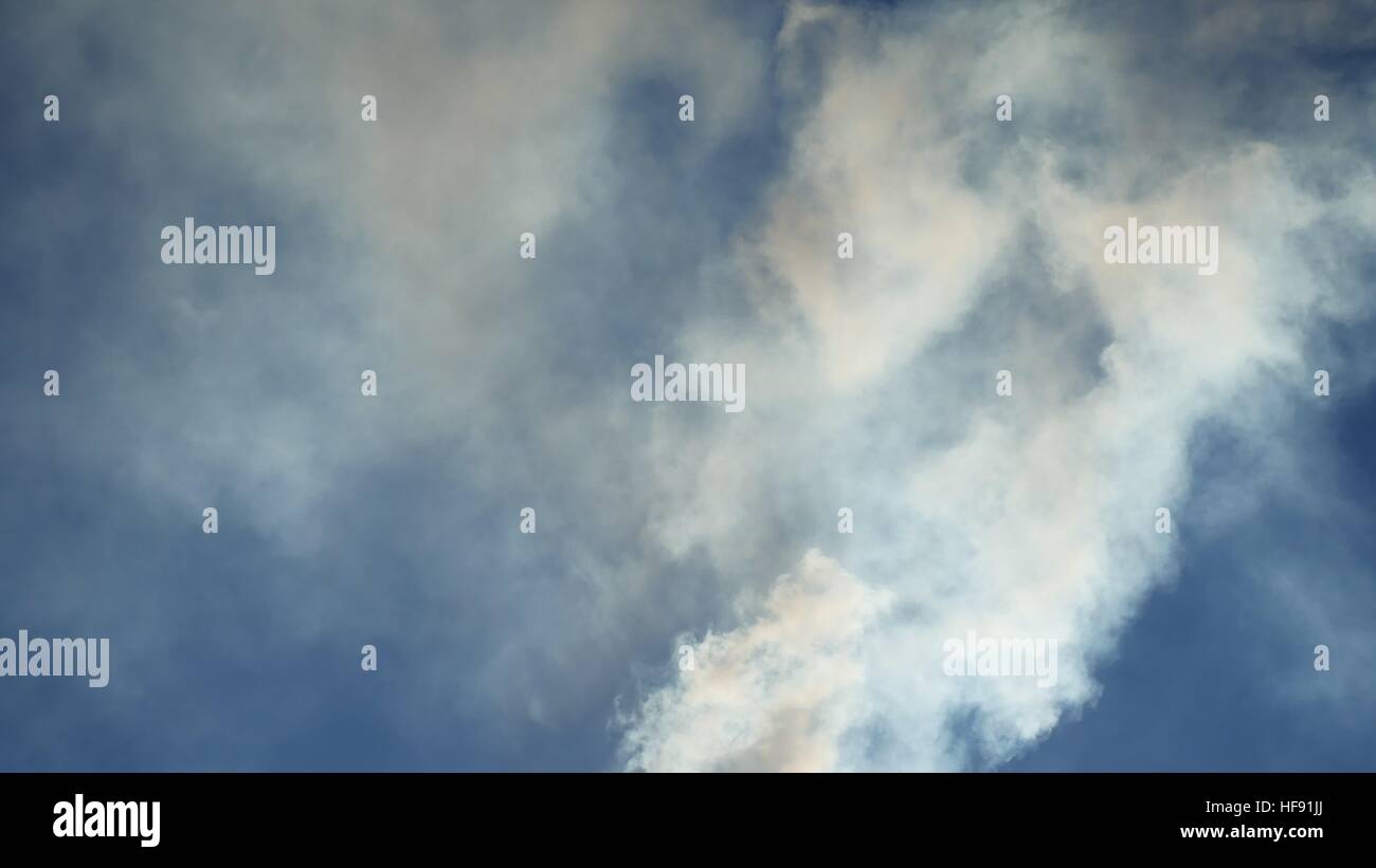white smoke against a blue cloud sky sunlight nature landscape Stock ...