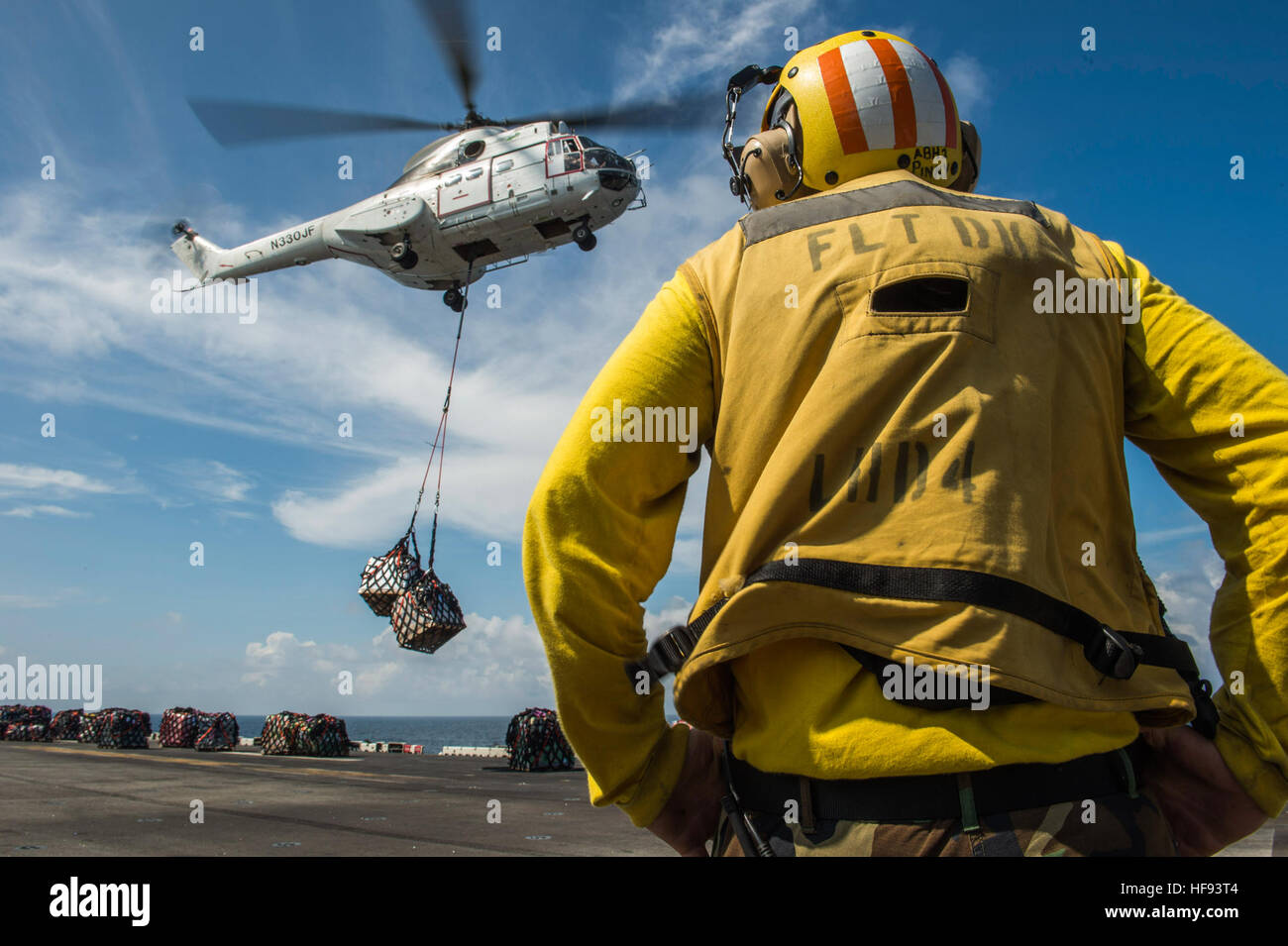 An SA-330 Puma helicopter prepares to place cargo onto the flight deck of the amphibious assault ship USS Boxer (LHD 4) during a vertical replenishment. Boxer is the flagship for the Boxer Amphibious Ready Group and, with the embarked 13th Marine Expeditionary Unit, is deployed in support of maritime security operations and theater security cooperation efforts in the U.S. 5th Fleet area of responsibility. (U.S. Navy photo by Mass Communication Specialist 2nd Class Kenan O'Connor/Released) Boxer VERTREP 131014-N-JP249-097 Stock Photo