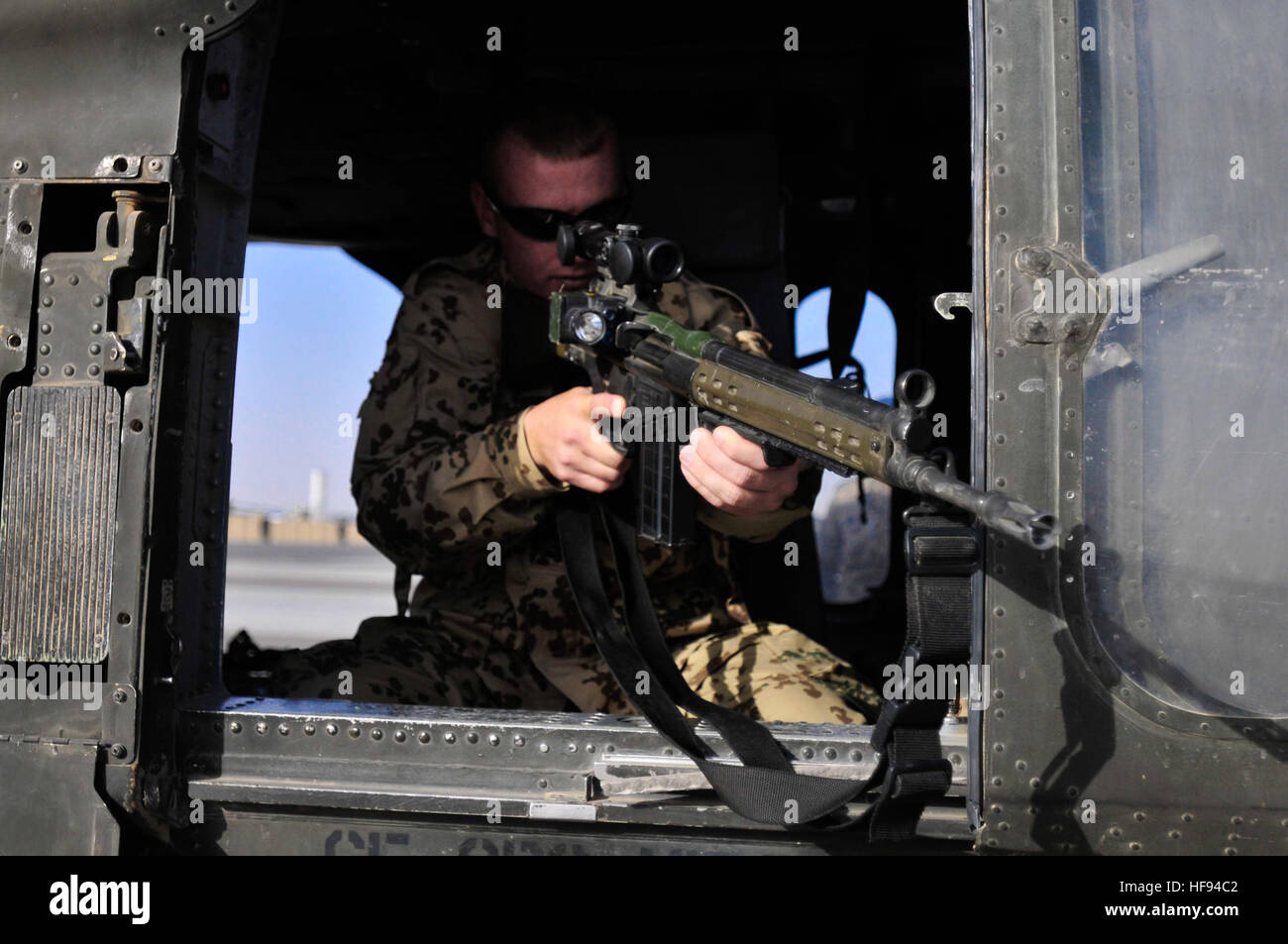 A German soldier looks through the scope mounted to his G3 rifle while aboard a UH-60L Blackhawk helicopter during an aircraft familiarization demonstration at Mazar-e-Sharif, Afghanistan, June 13, 2011. The Soldier is assigned to the International Security Assistance Force. (U.S. Navy photo by Mass Communication Specialist 2nd Class Nicholas A. Garratt/Released) Bundeswehr Soldat G3 Afghanistan Stock Photo
