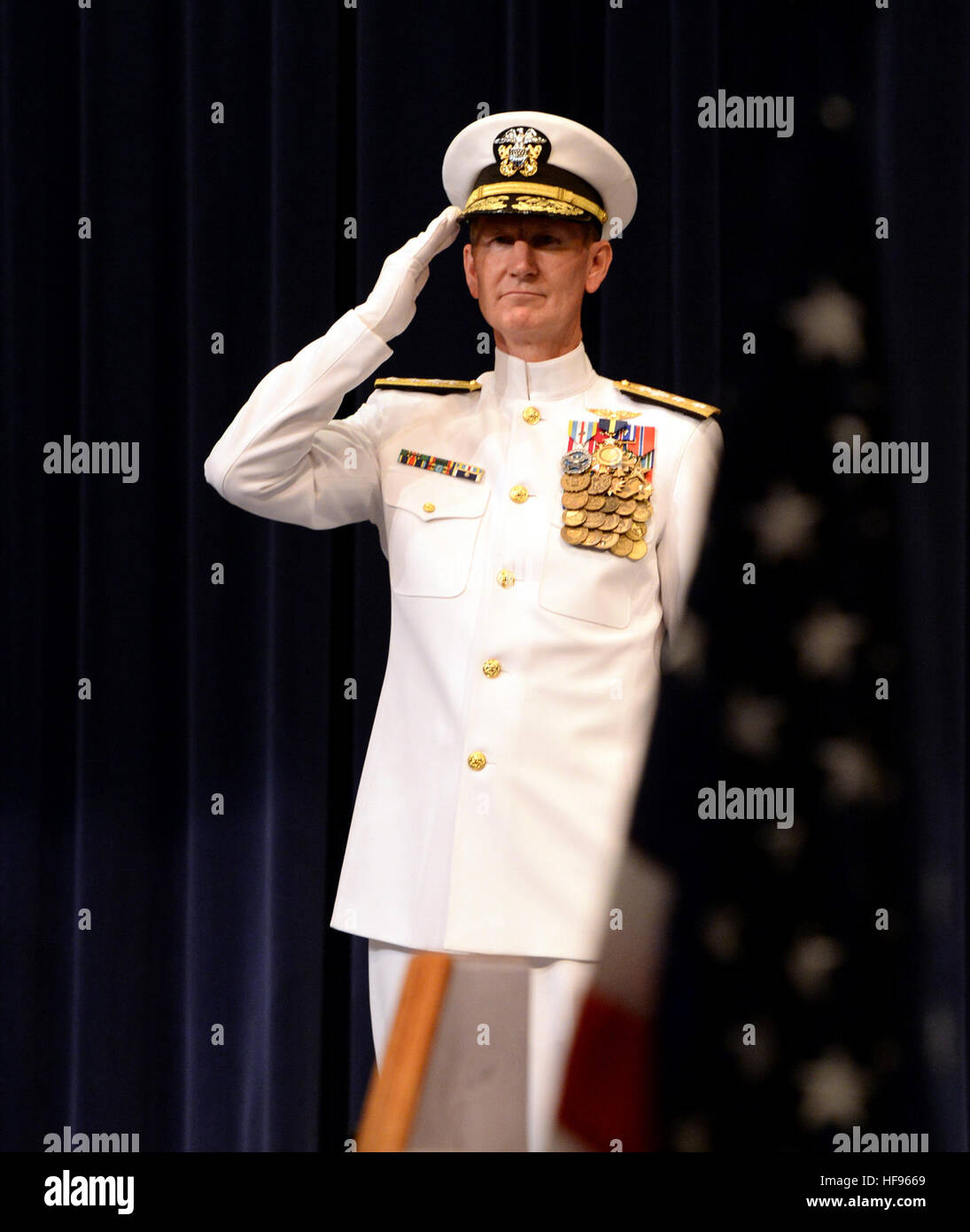 Rear Adm. Walter E. 'Ted' Carter Jr., renders honors during colors as part of a change of command ceremony at U.S. Naval War College (NWC) in Newport, R.I., with Chief of Naval Operations Adm. Jonathan Greenert. During the ceremony, and Rear Adm. P. Gardner Howe III relieved Carter and became the 55th president and first Navy SEAL in command of the NWC. Howe, a U.S. Naval Academy, Naval Postgraduate School and National War College graduate, holds dual Master of Arts degrees in national security and reports from his most recent assignment as commander of Special Operations Command, Pacific. Car Stock Photo