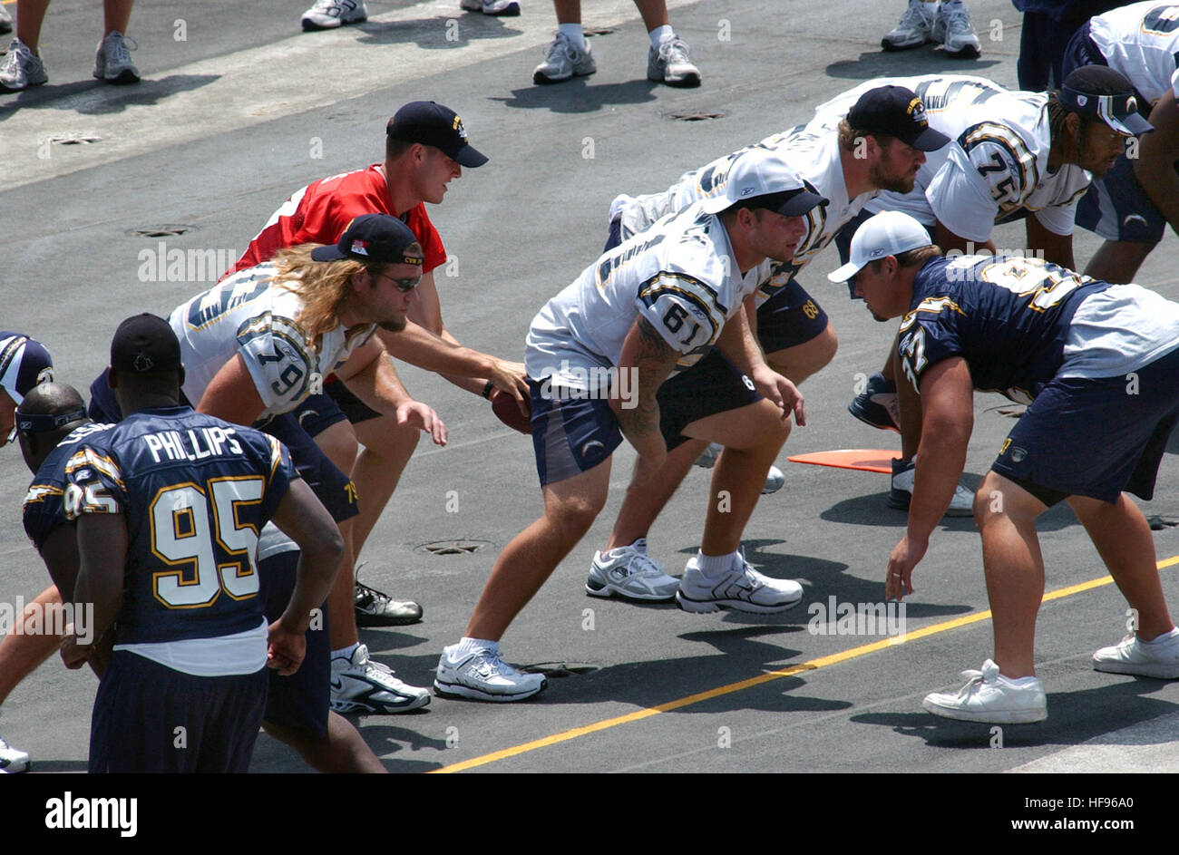 060811-N-4776G-075   San Diego, Calif. (Aug. 11, 2006) – Starting Quarterback for the National Football League (NFL) San Diego Chargers, Philip Rivers (17), takes the snap from Center, Nick Hardwick (61), during a light practice on the flight deck aboard USS Ronald Reagan (CVN 76). The Chargers held practice aboard the Navy's newest nuclear powered aircraft carrier in preparation for their first pre-season game against the Green Bay Packers, August 12. During pre-game ceremonies, a military appreciation game will involve Ronald Reagan Sailors and the unfurling of a giant American display flag. Stock Photo