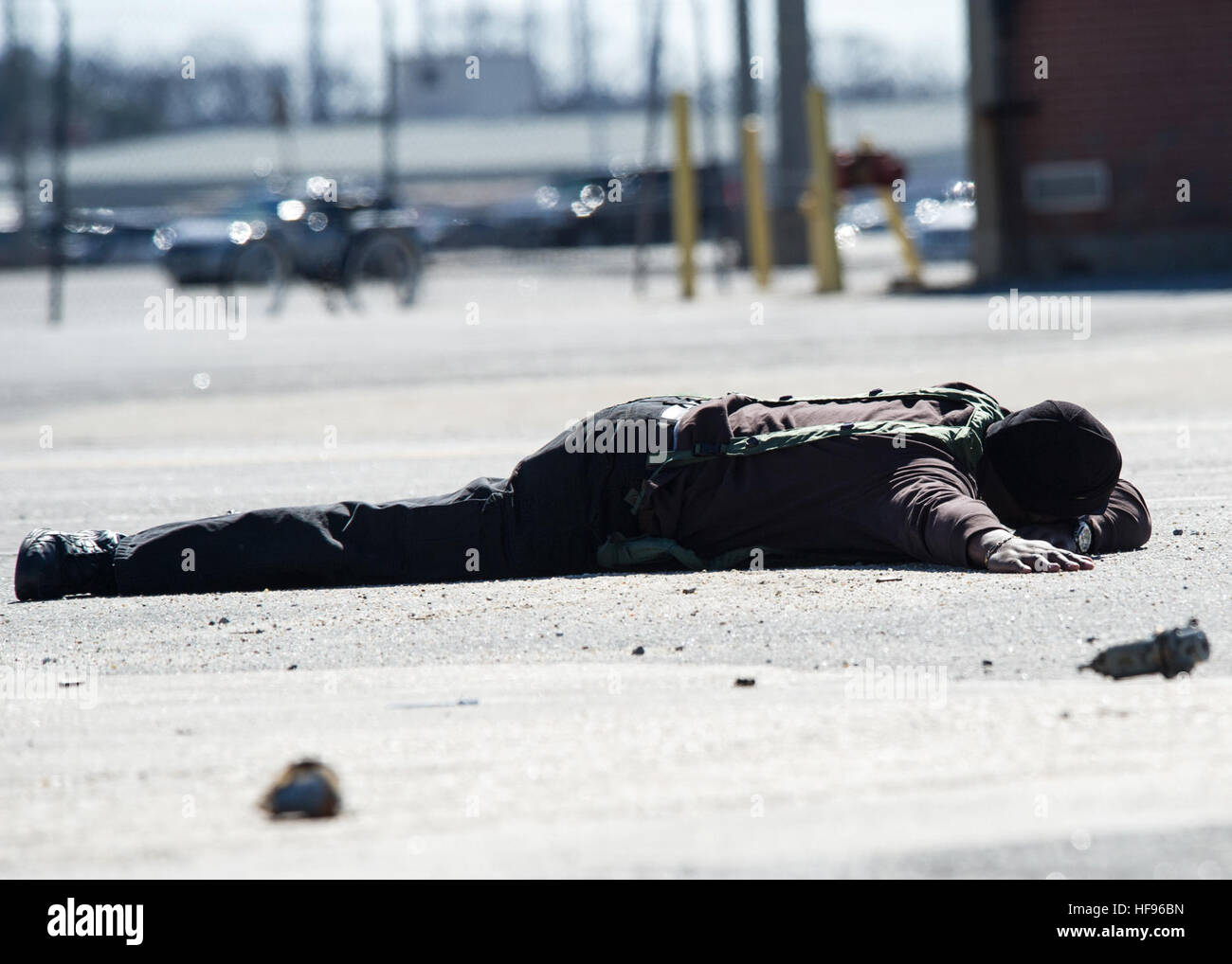 Charles Streat lays on the ground after being disarmed by U.S. Navy police Feb. 27, 2014, during a vehicle-borne improvised explosive device response exercise as part of Solid Curtain-Citadel Shield (SC-CS) 2014 at Naval Station Norfolk, Va. SC-CS is an annual exercise designed to enhance the training and readiness of U.S. Navy security forces to respond to threats to installations and units. (U.S. Navy photo by Mass Communication Specialist 3rd Class Andrew Schneider/Released) Charles Streat lays on the ground after being disarmed by U.S. Navy police Feb. 27, 2014, during a vehicle-borne impr Stock Photo