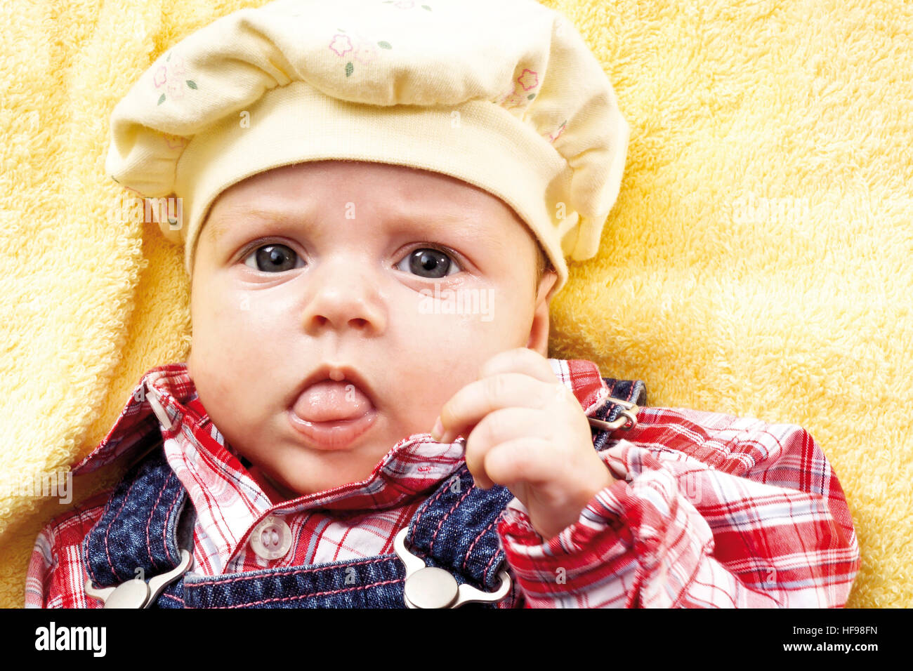 Baby wearing overalls and a hat Stock Photo Alamy