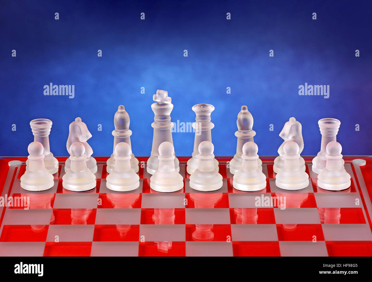 Glass chess on the chessboard - blue background Stock Photo