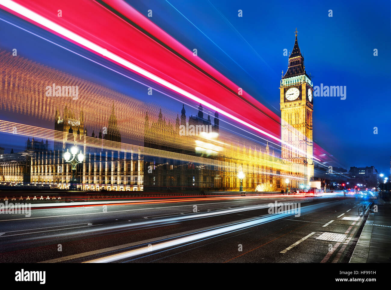 Big Ben, one of the most prominent symbols of both London and England, as shown at night along with the lights of the cars passing Stock Photo