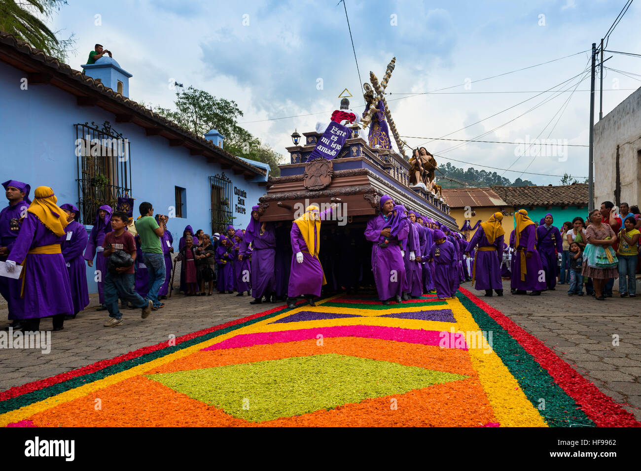 Antigua, Guatemala - April 16, 2014: Man wearing purple robes, carrying a float (anda) during the Easter celebrations in Antigua Stock Photo
