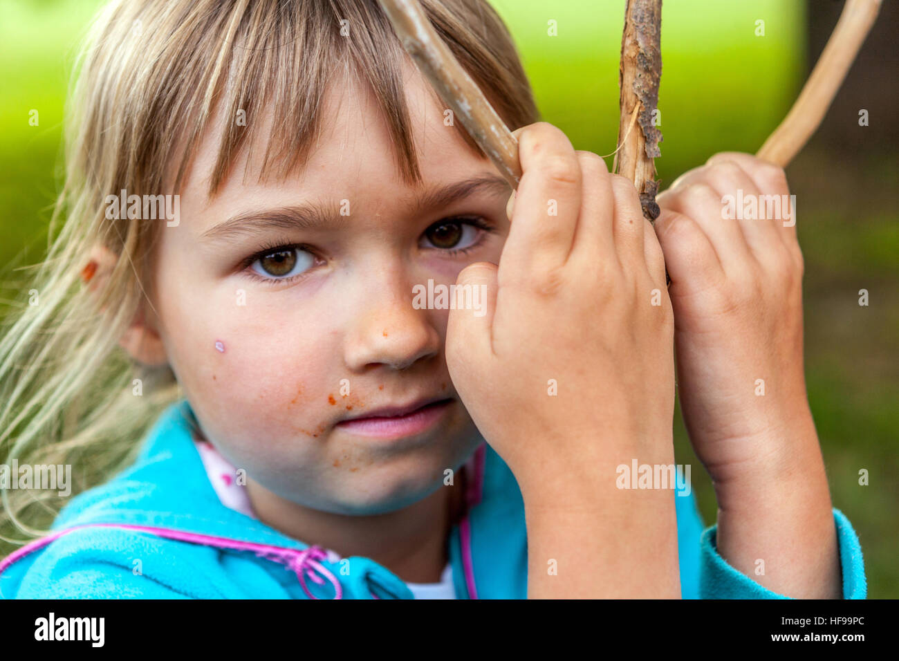 Portrait of a six-year girl with a wooden stick Stock Photo