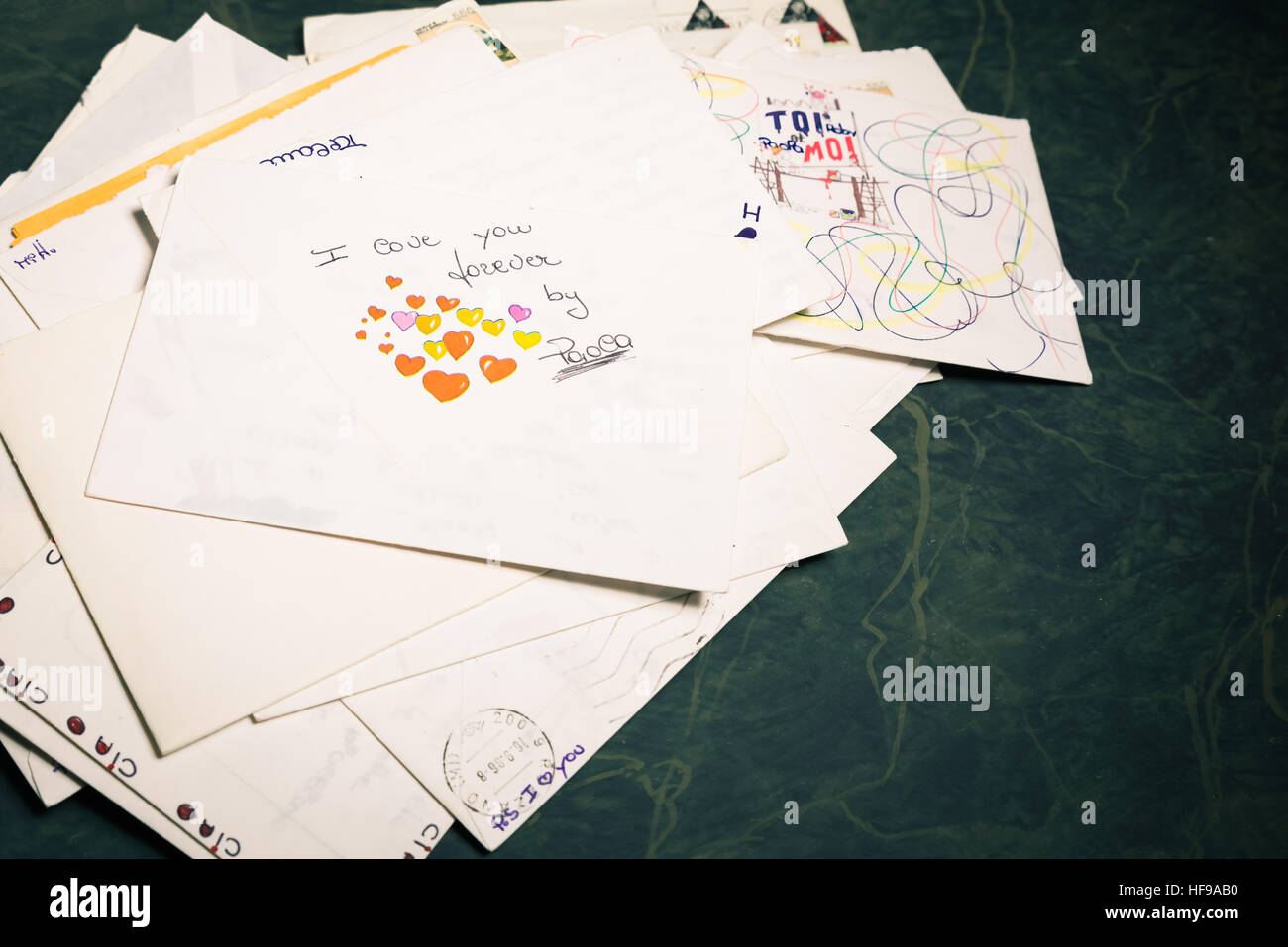 Big stack of mails, pile of papers, or heap of letters, above a letter saying 'I love you forever ...'. Stock Photo