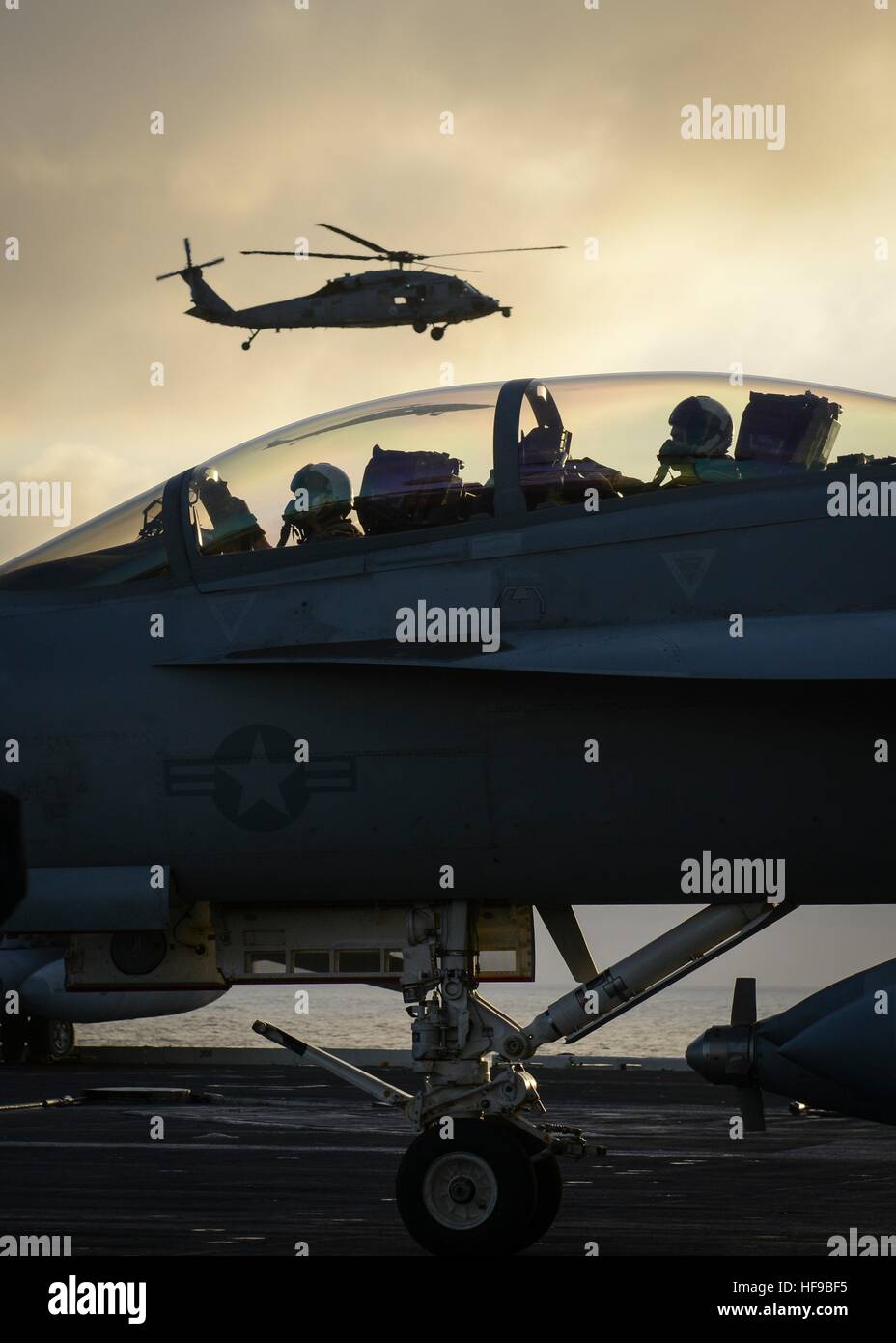 A Boeing F/A-18E Super Hornet fighter aircraft taxis on the flight deck of the USN Nimitz-class aircraft carrier USS Nimitz at sunset December 5, 2016 in the Pacific Ocean. Stock Photo