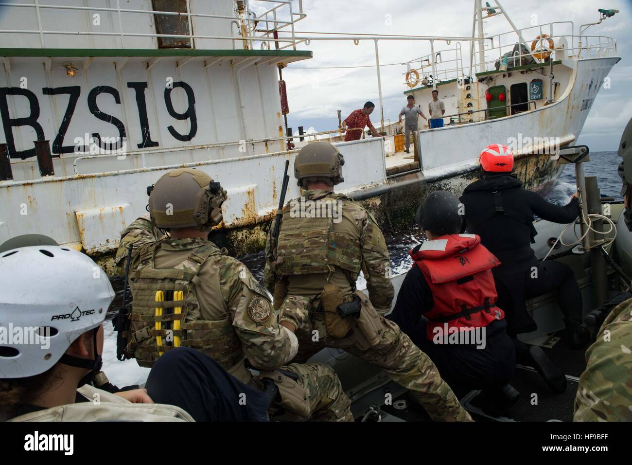 U.S. soldiers and U.S. Coast Guard officers approach a Chinese fishing vessel during an Oceania Maritime Security Initiative mission November 29, 2016 in the Pacific Ocean. Stock Photo