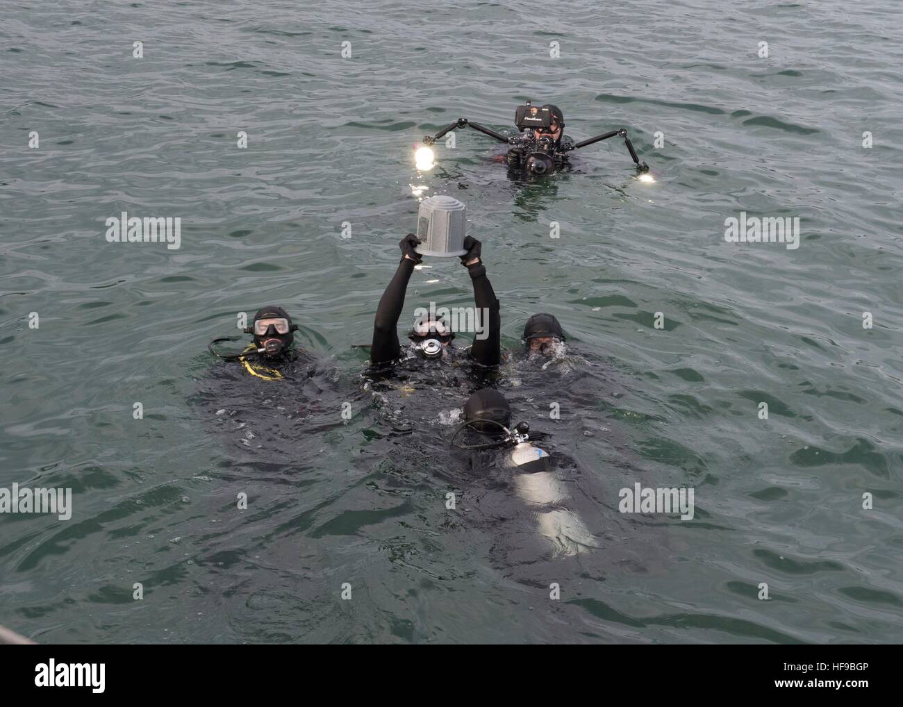 USN soldiers and National Park Service divers prepare the ashes of John D. Anderson for interment at a memorial service during the 75th Anniversary Commemoration of the Pearl Harbor attacks at the USS Arizona Memorial December 7, 2016 in Pearl Harbor, Hawaii. Stock Photo