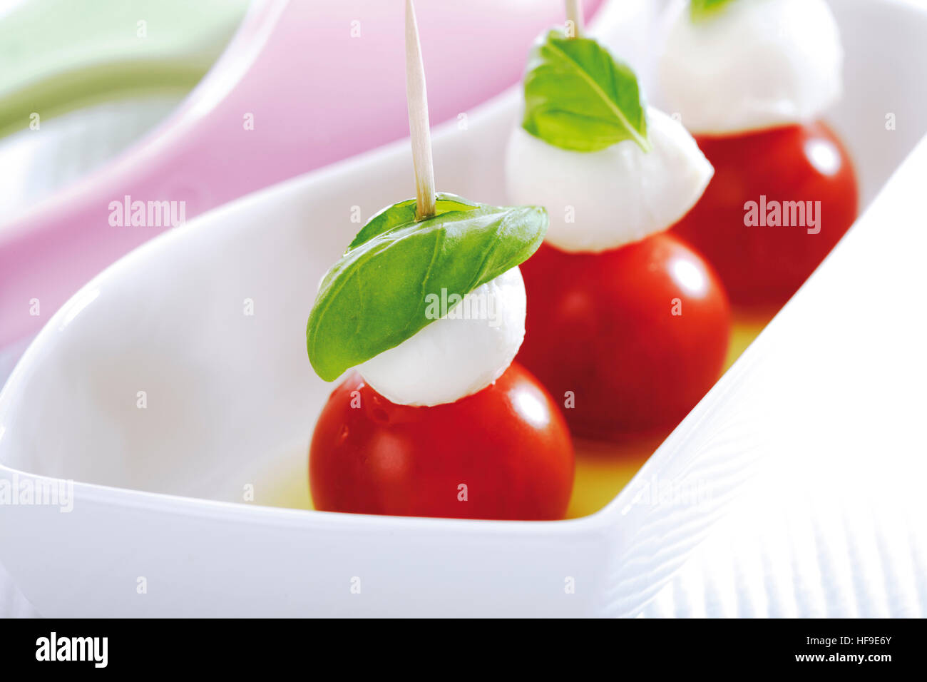 Cocktail tomatoes topped with mozzarella and basil Stock Photo Alamy