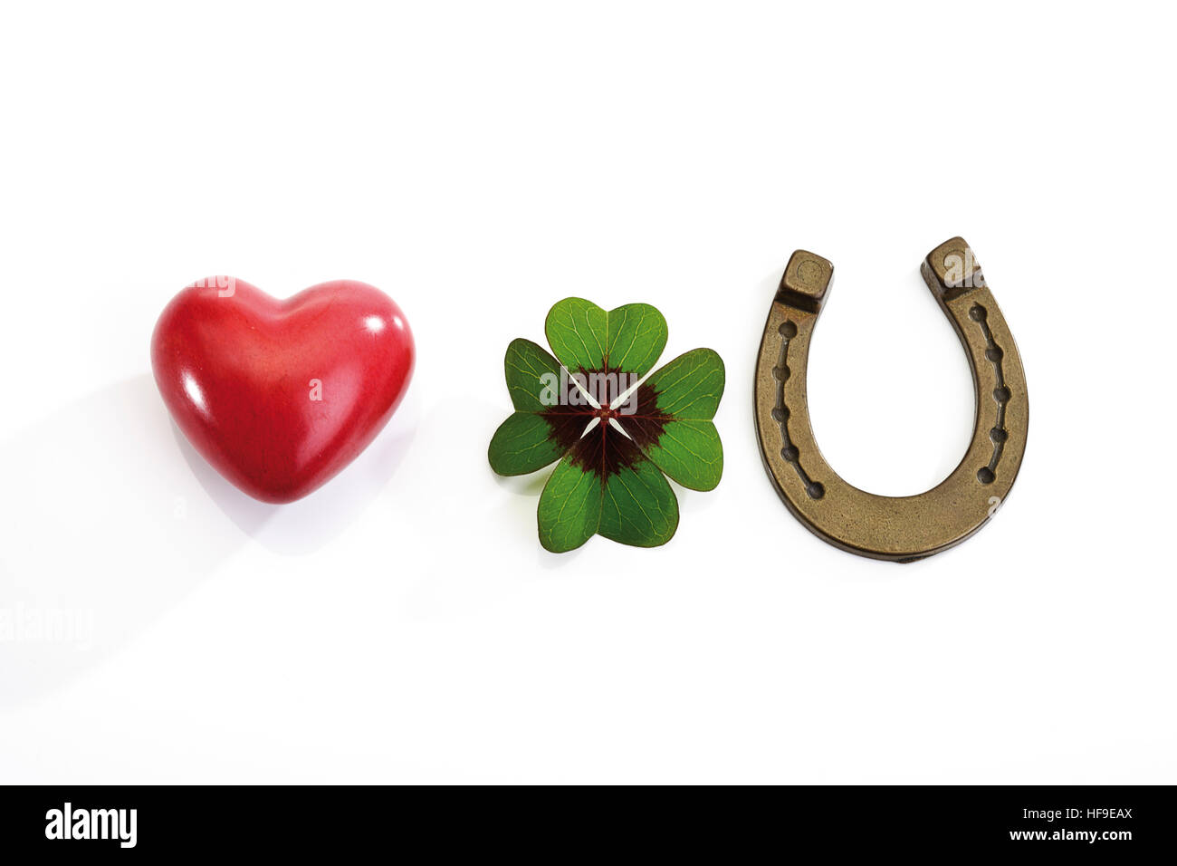 Horseshoe, four-leaf clover and a red heart Stock Photo