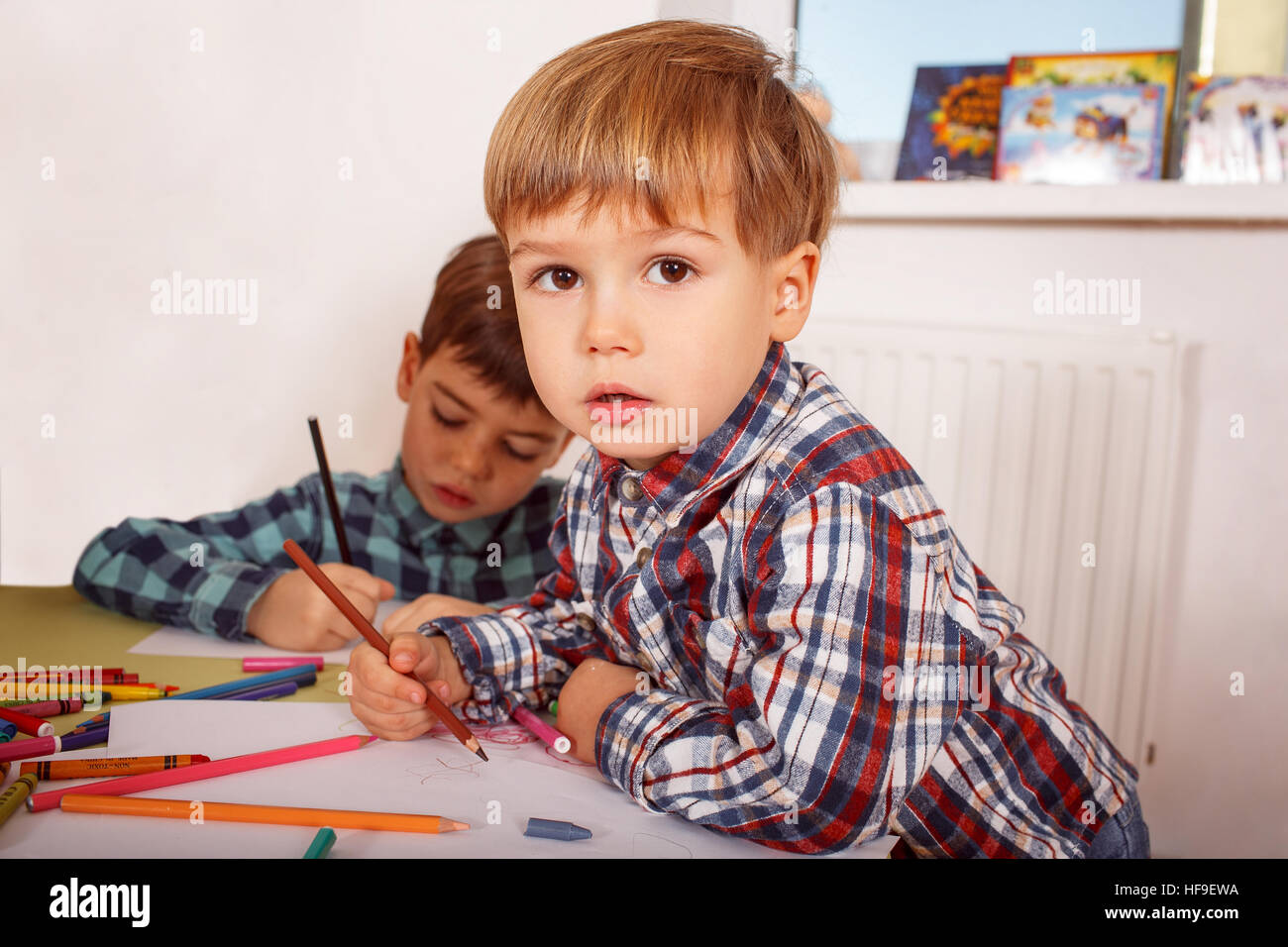 Three years old boy drawing using a pencil in kindergarten Stock Photo -  Alamy