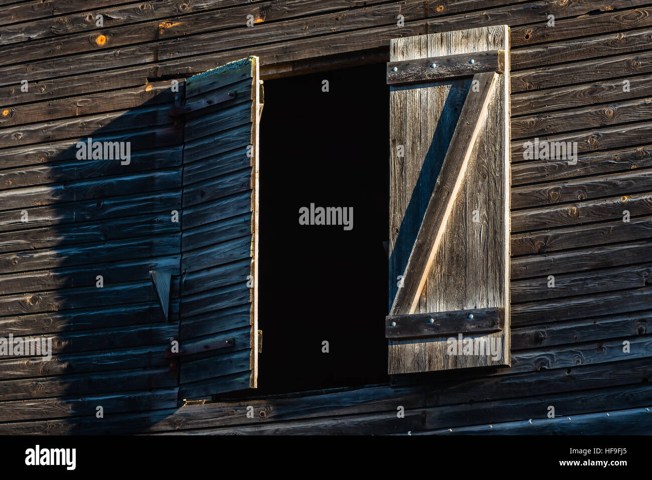 Open hatch on old and dark building seen from low angle. Stock Photo