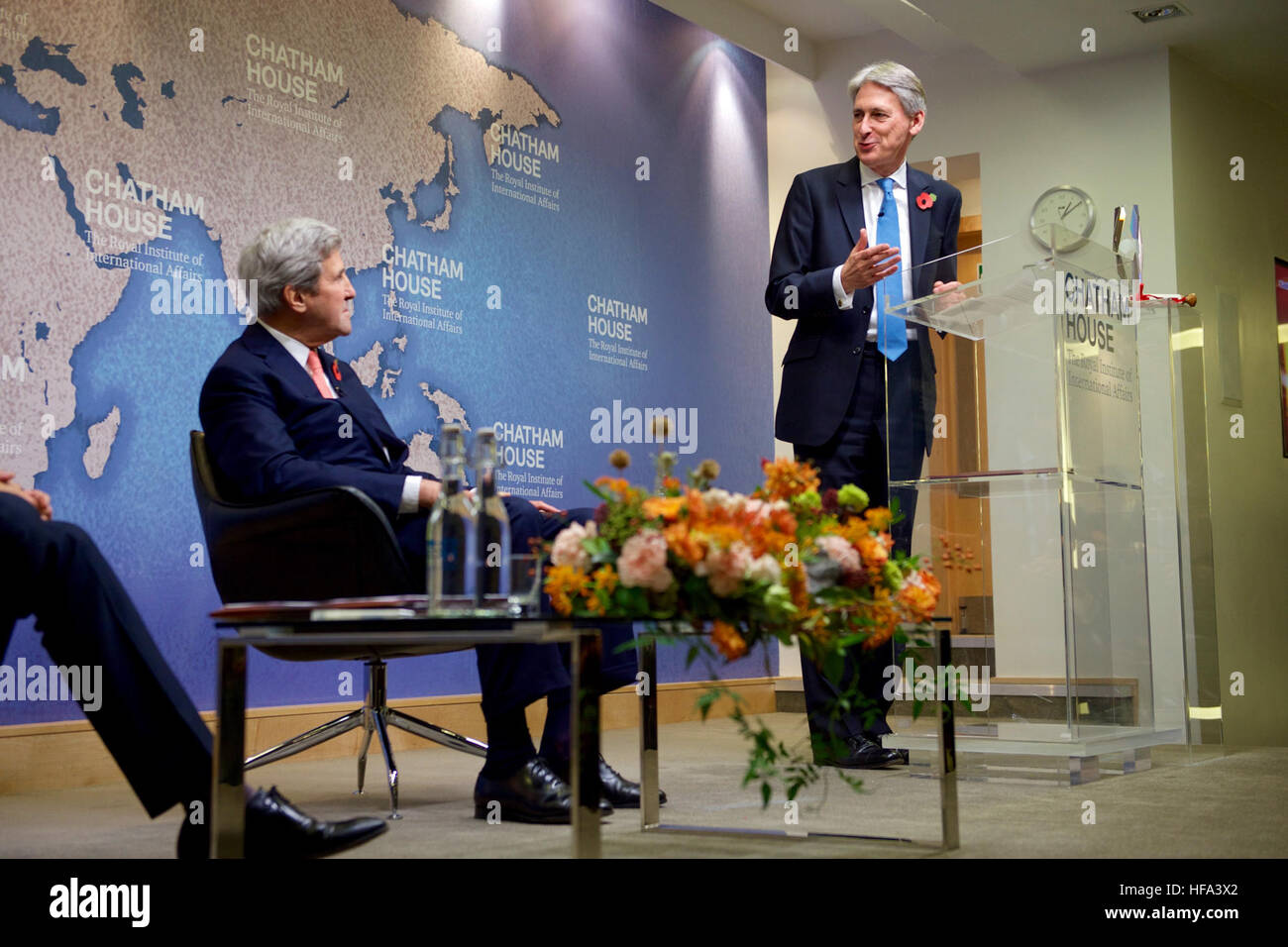 U.S. Secretary of State John Kerry listens as his former counterpart, British Chancellor of the Exchequer Philip Hammond, makes remarks before the Secretary and Iranian Foreign Minister Javad Zarif received the Chatham House Prize from the famed international think-tank in London, U.K., on October 31, 2016. Stock Photo