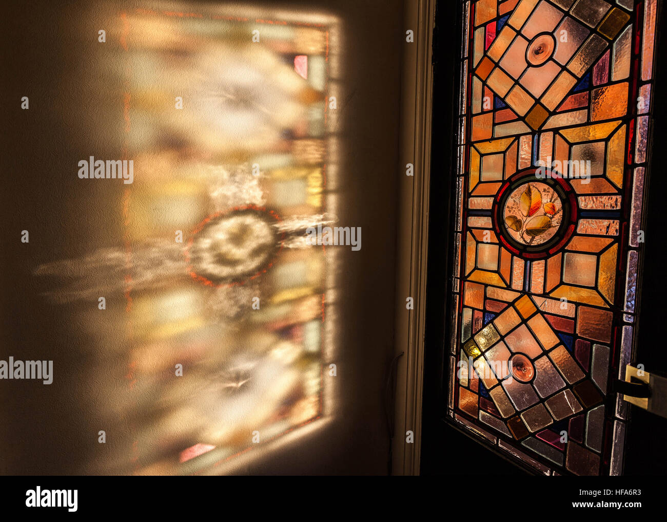 Stained glass window colours and patterns projected on the wall by sunlight. Stock Photo