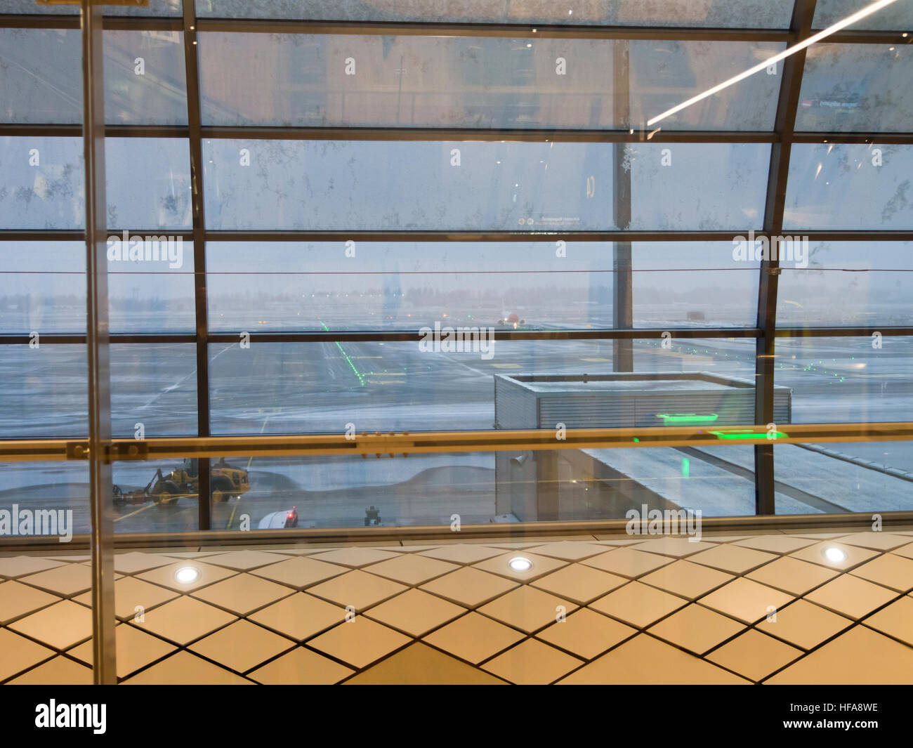 New airport terminal in Oslo Norway 2016, looking out at dreary weather for flying, dark, snow, sleet, normal winter conditions Stock Photo