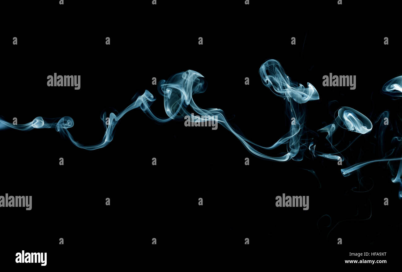Blue smoke trail on black background Stock Photo - Alamy