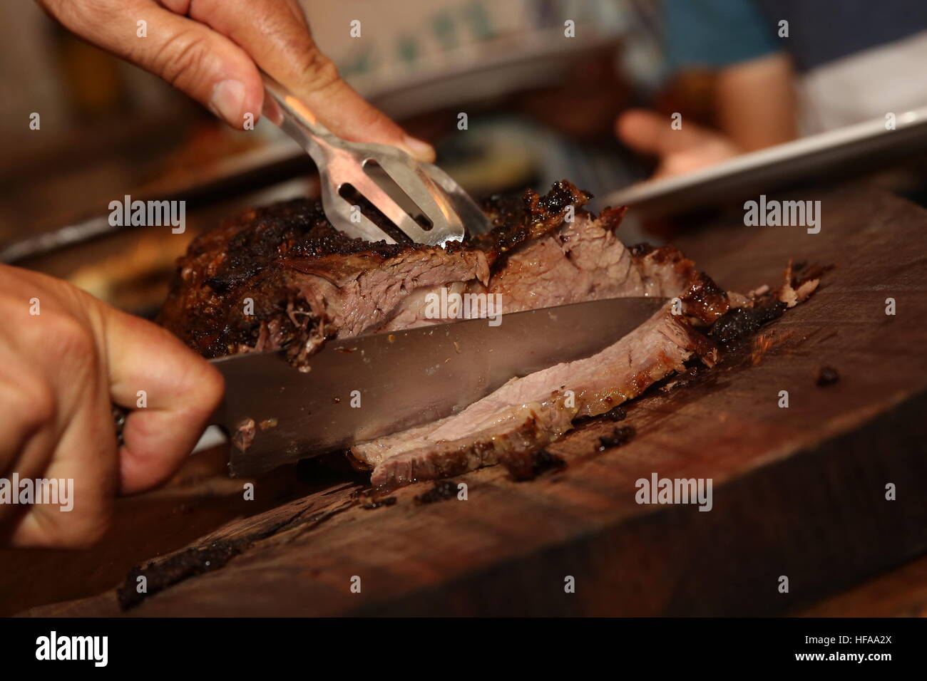 Cutting slices of Roast Beef at a buffet table Stock Photo