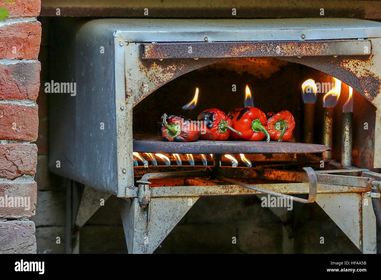 Red bell peppers in an open flame gas oven Stock Photo