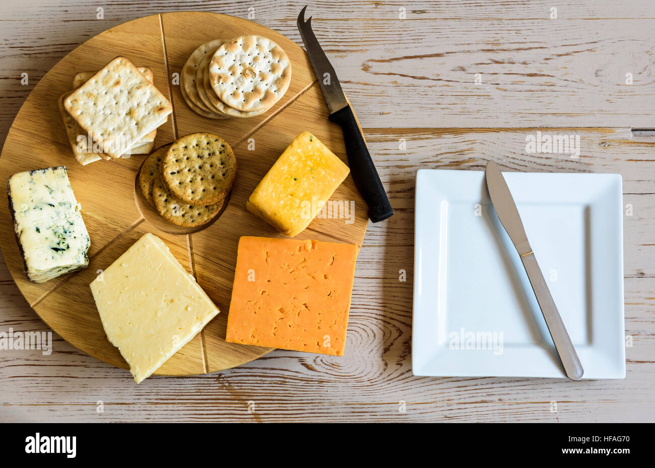 Selection of cheeses on a round cheese board, sitting on an old table Stock Photo Alamy