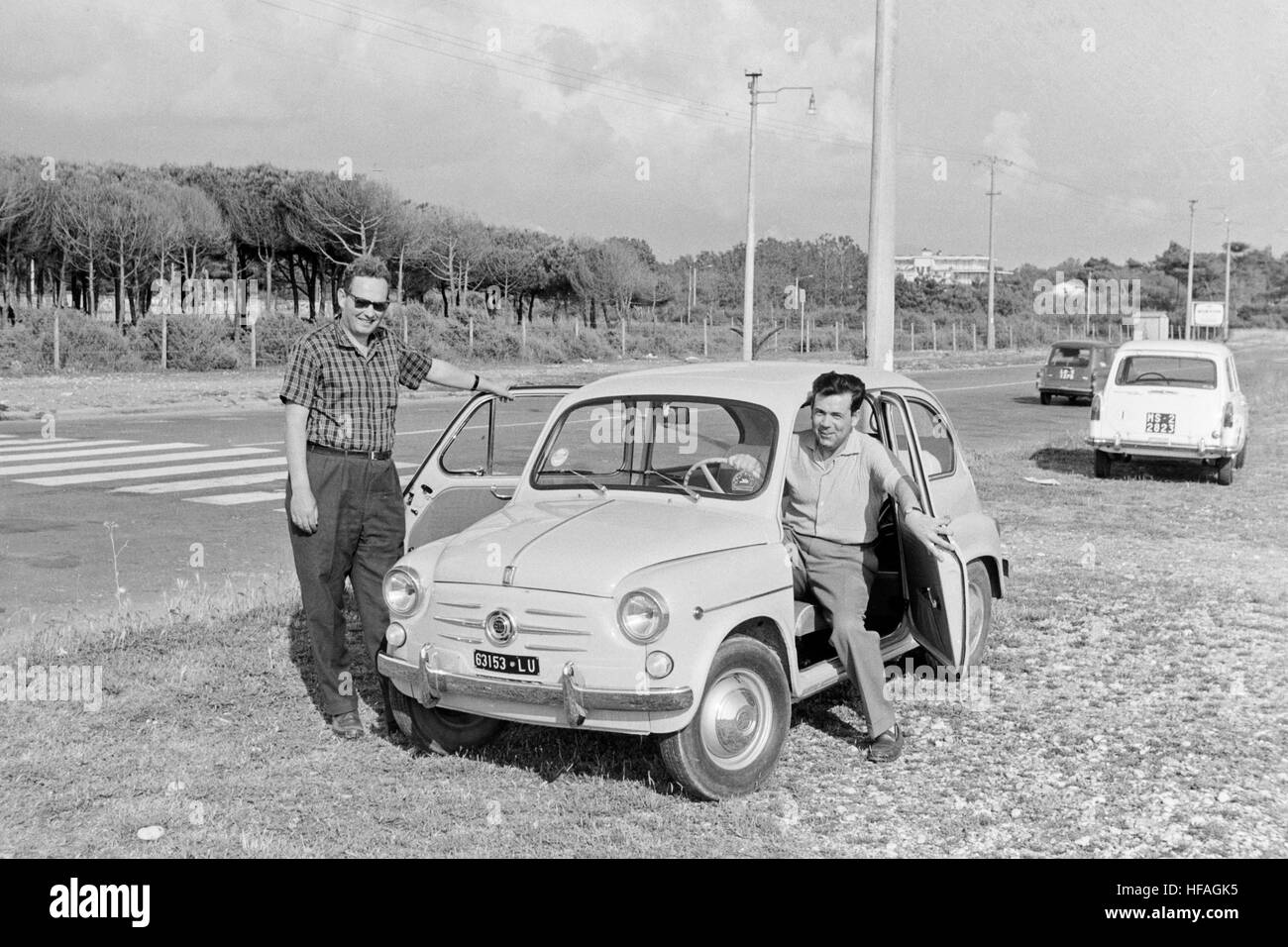 Two men posing with a Fiat 500 motor car in Italy during the 1960s. Stock Photo