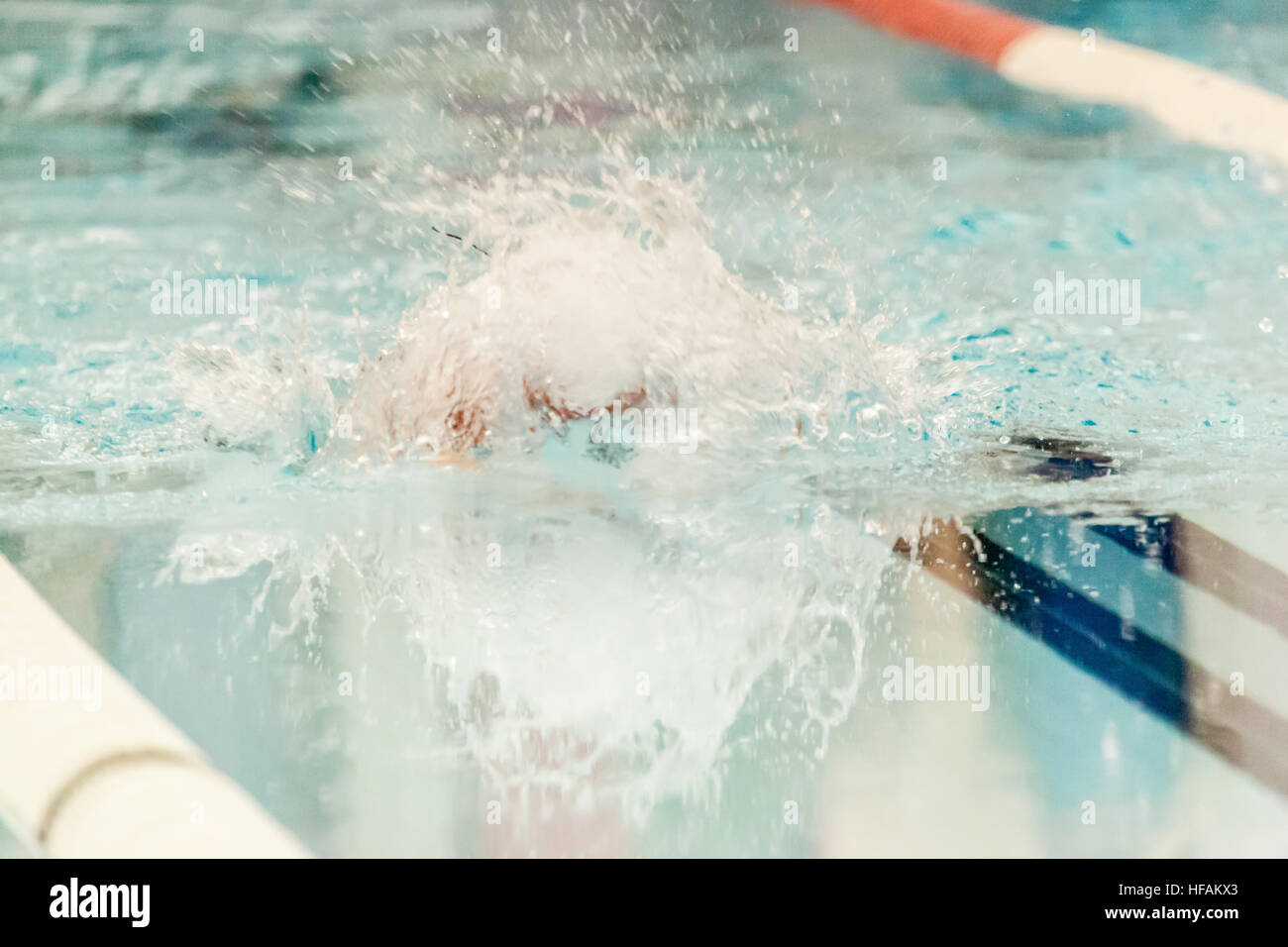 A swimmer makes a splash swimming during a swim competition Stock Photo