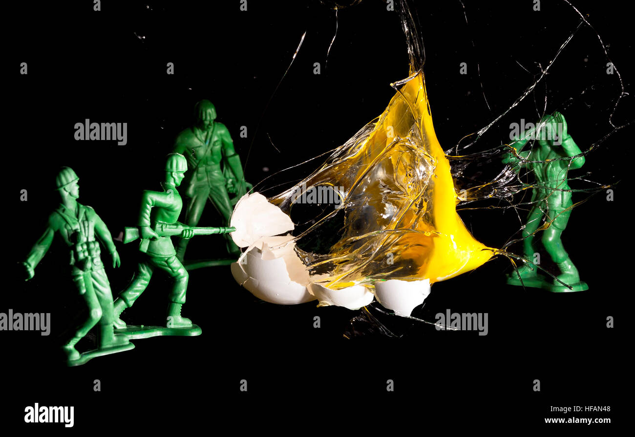 Exploding high speed egg with toy army men. Concept for war and death Stock Photo