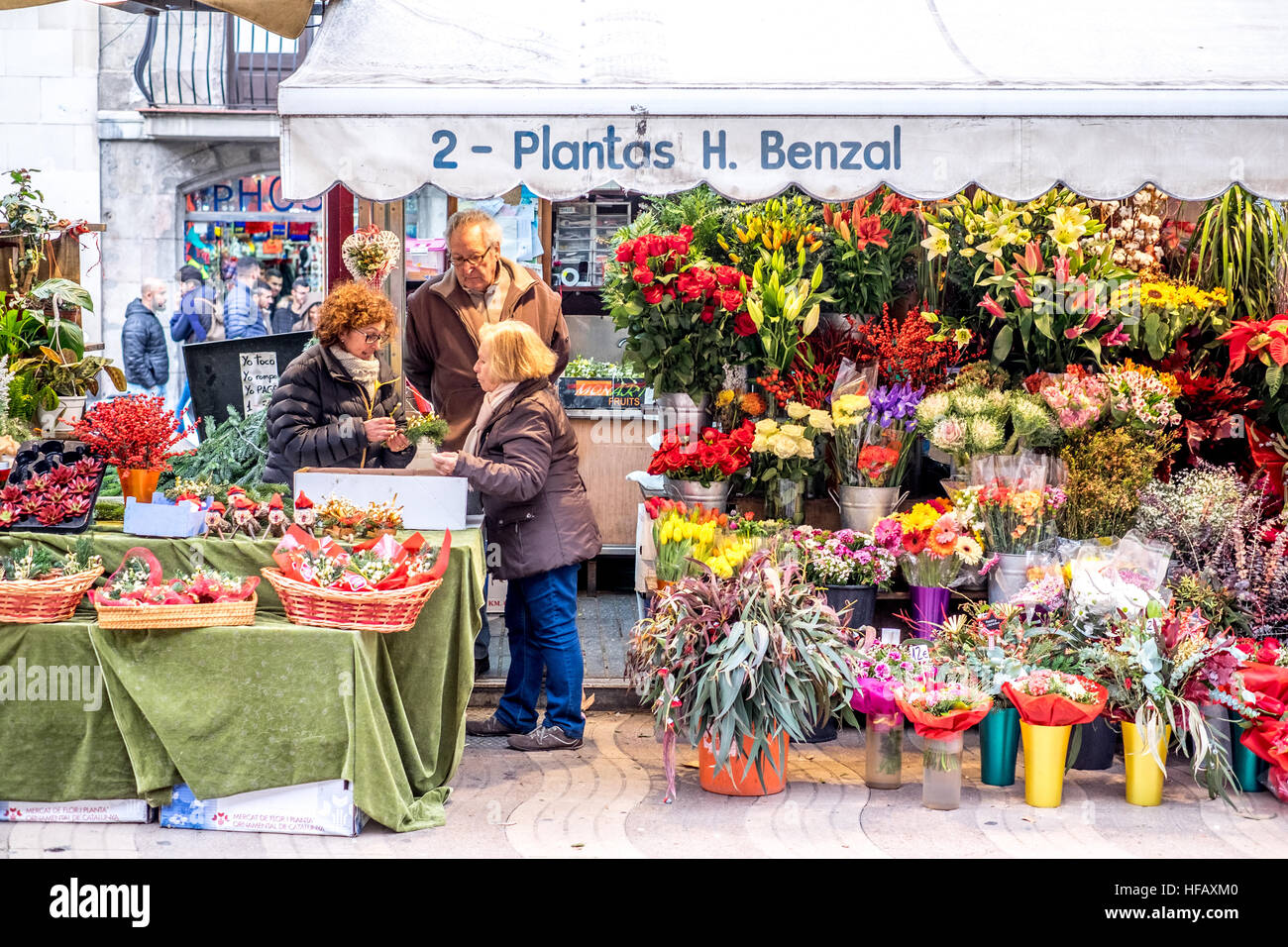 Women sell their beautiful flowers at a roadside market in Spain. Stock Photo