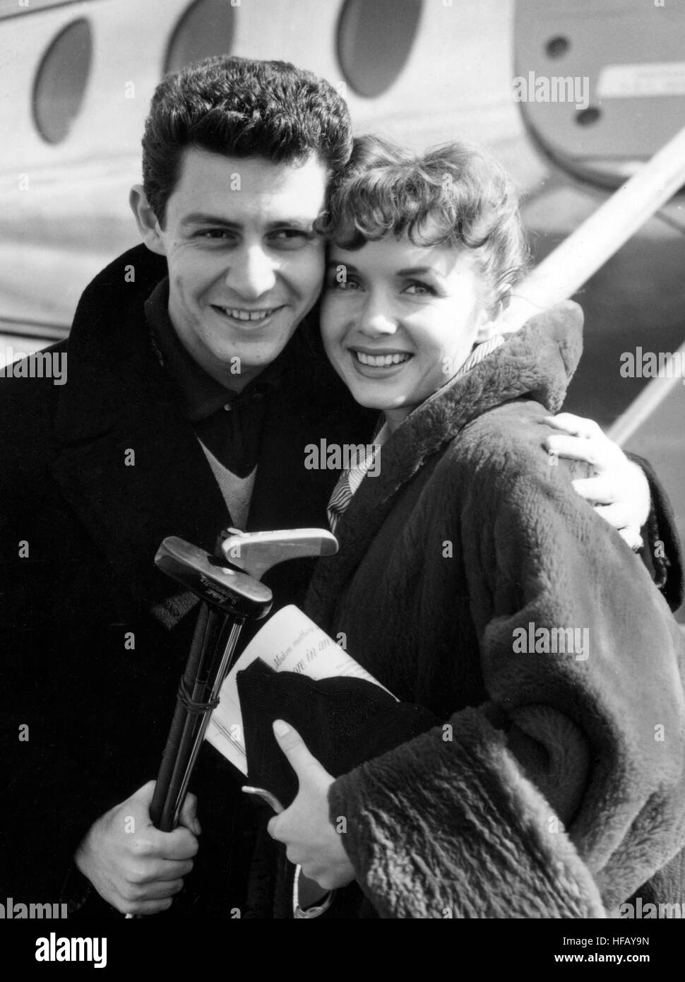 American heart-throb singer Eddie Fisher and his bride-to-be actress Debbie Reynolds huddle together as they wait to go aboard a BEA Viscount at London Airport to fly to Lisbon. They plan to wed on June 17th. *Neg corrupt. Scanned from print Stock Photo