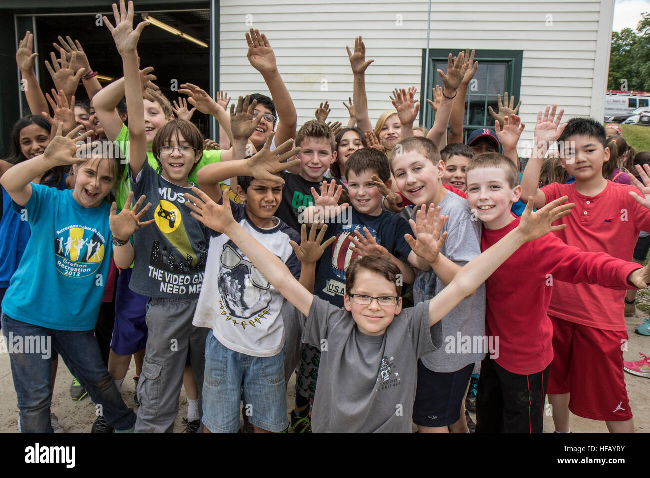 People working in a large vegetable garden - children showing off their dirty hands from working in the garden Stock Photo