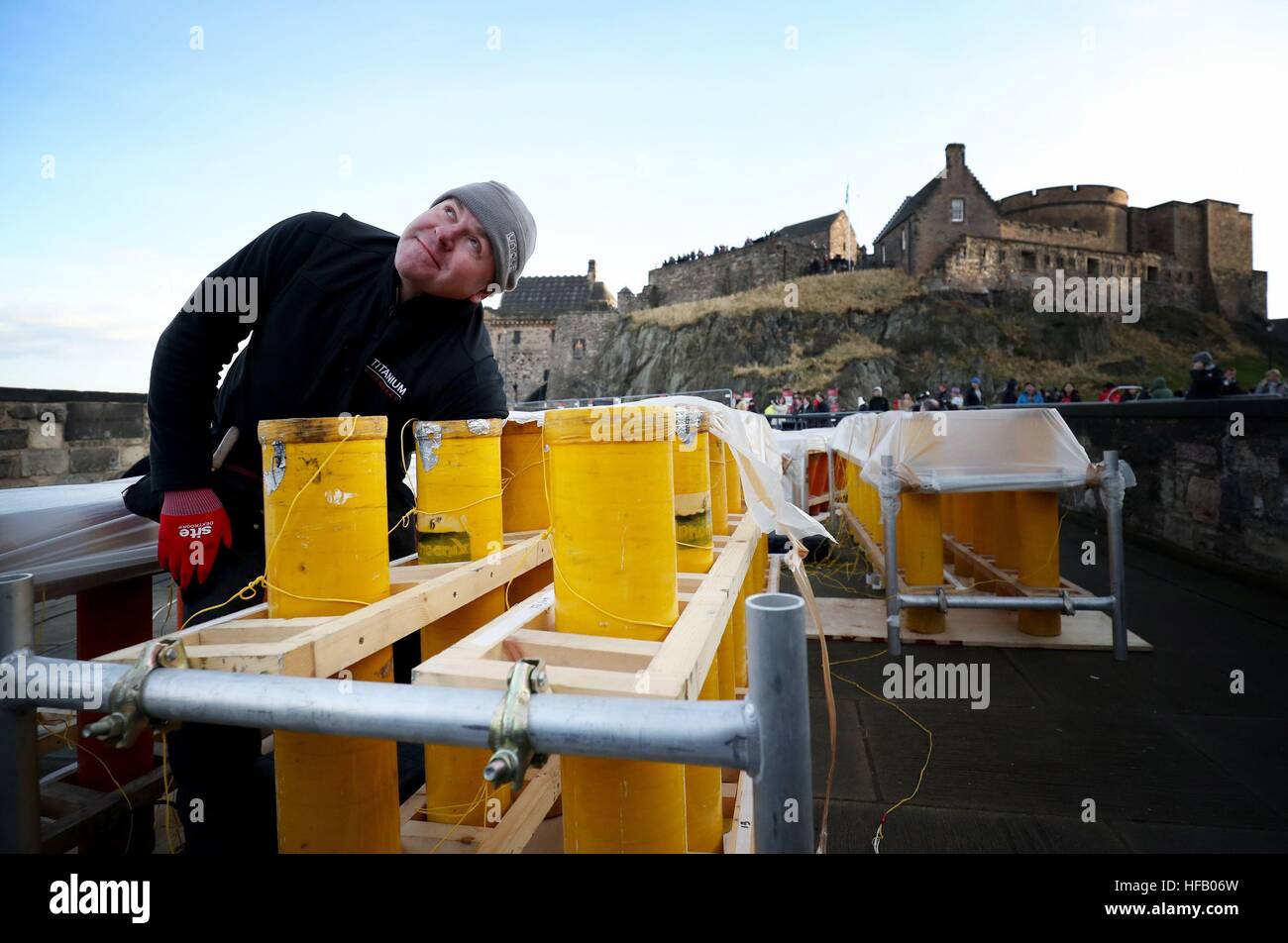 Pyro-technician Shaun Gibson from Titanium Fireworks sets up some of the 2.6 tonnes of fireworks along the ramparts of Edinburgh Castle ahead of the Hogmanay fireworks display for the New Year. Stock Photo