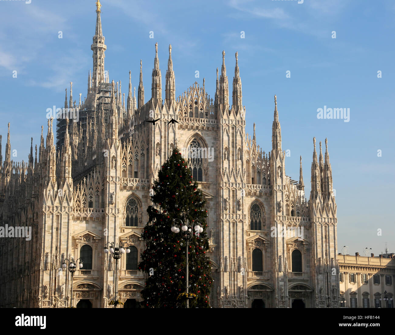 huge Christmas tree with red and silver balls  and the facade of the fantastic Cathedral of Milan in Italy Stock Photo