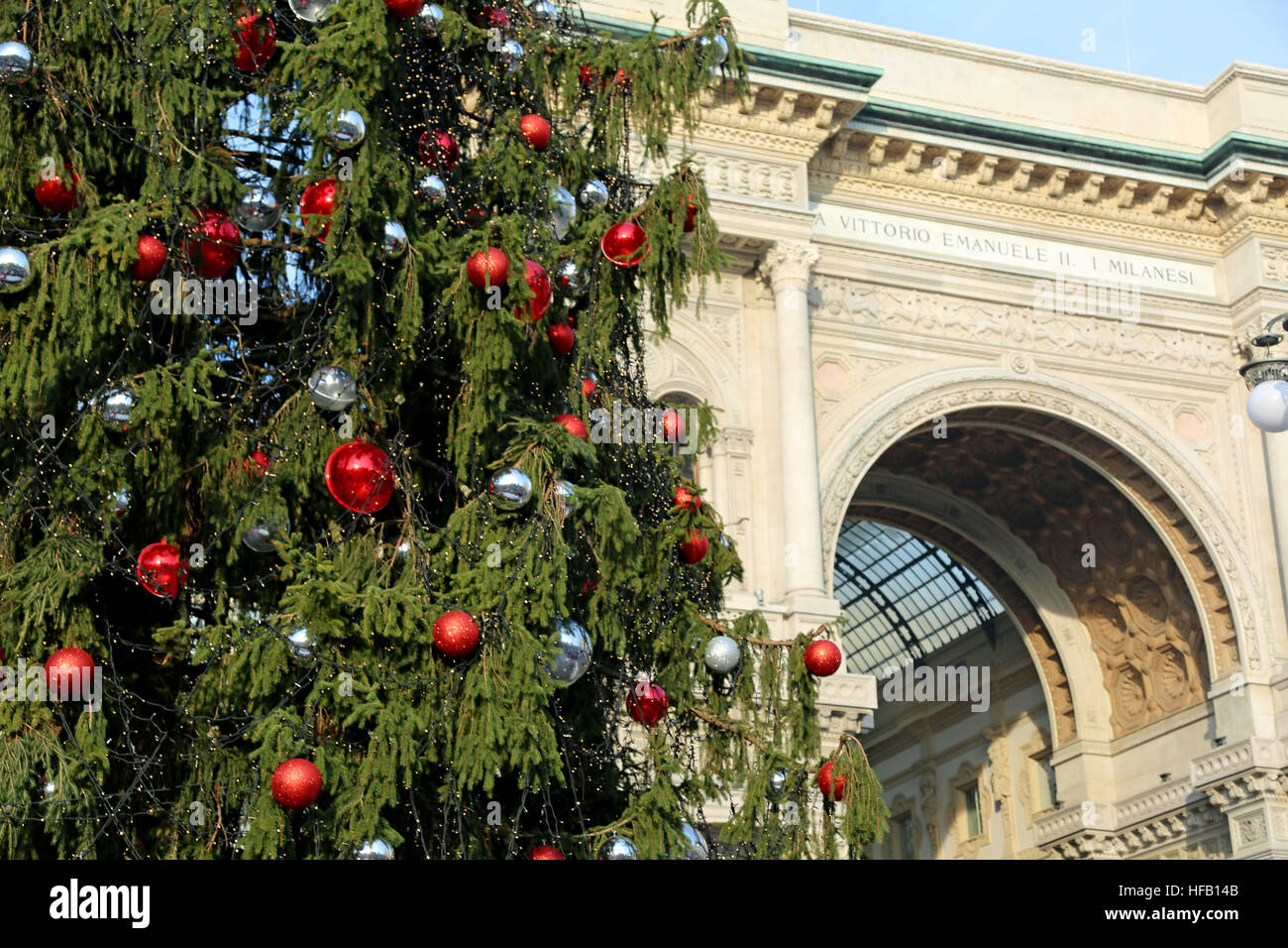 Huge ornated Christmas tree and building dedicated to the King of Italy Victor Emmanuel II in Milan in Italy Stock Photo