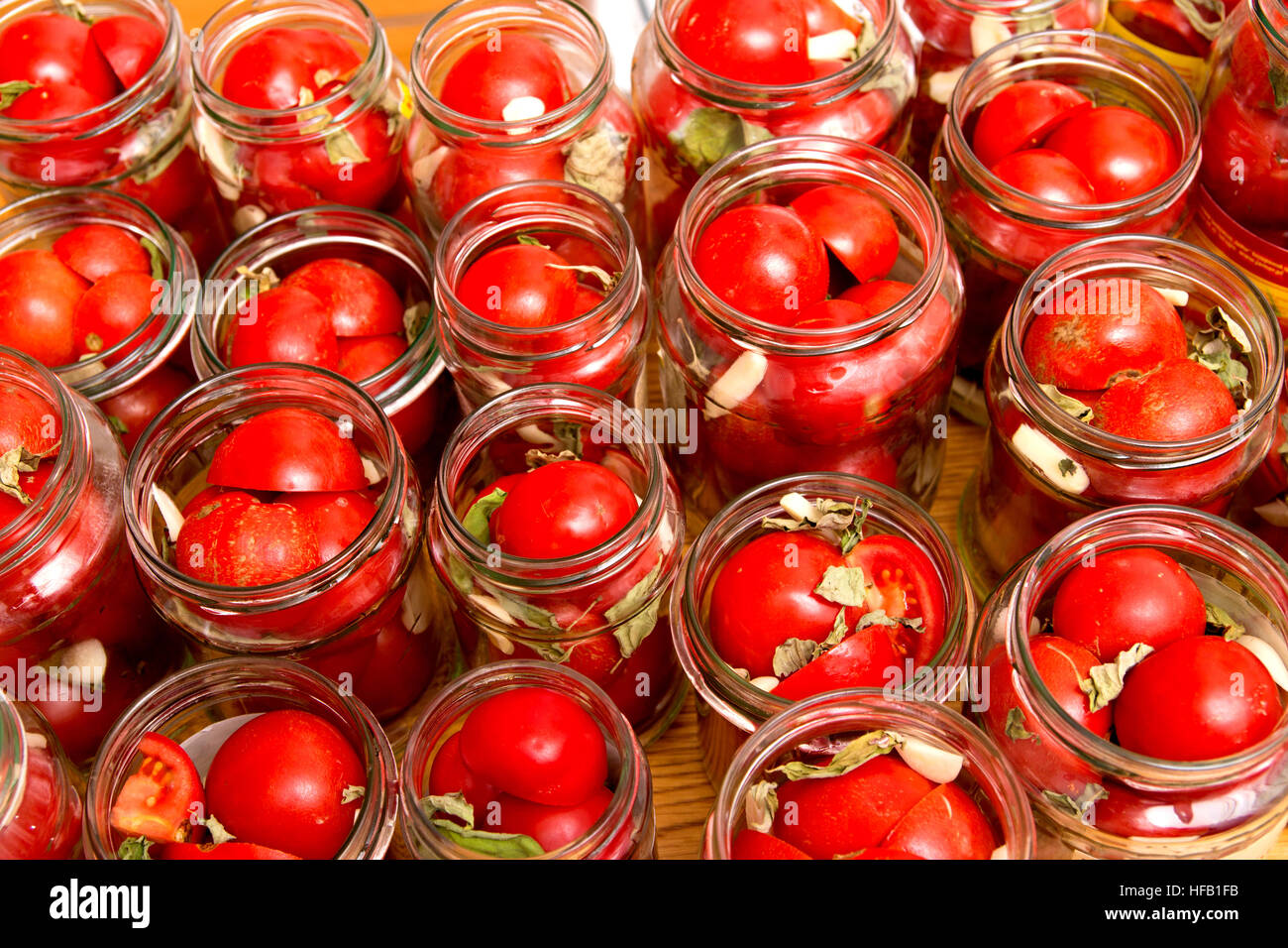 fresh red tomatos in jars ready to be flooded with salt water - preserves of winter Stock Photo