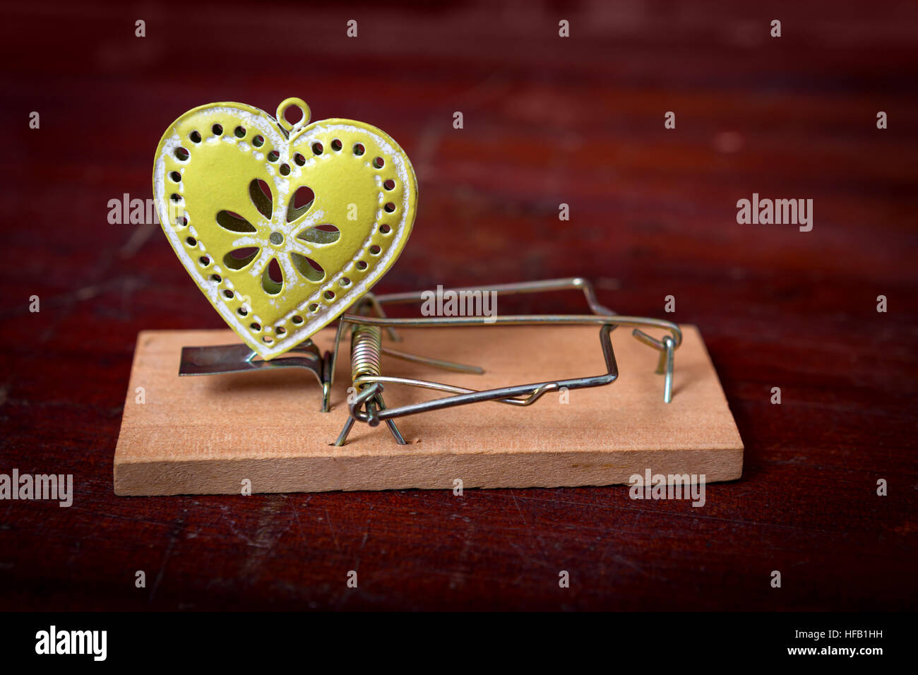 mouse trap with green heart as a bait - catching partners, feelings, love Stock Photo