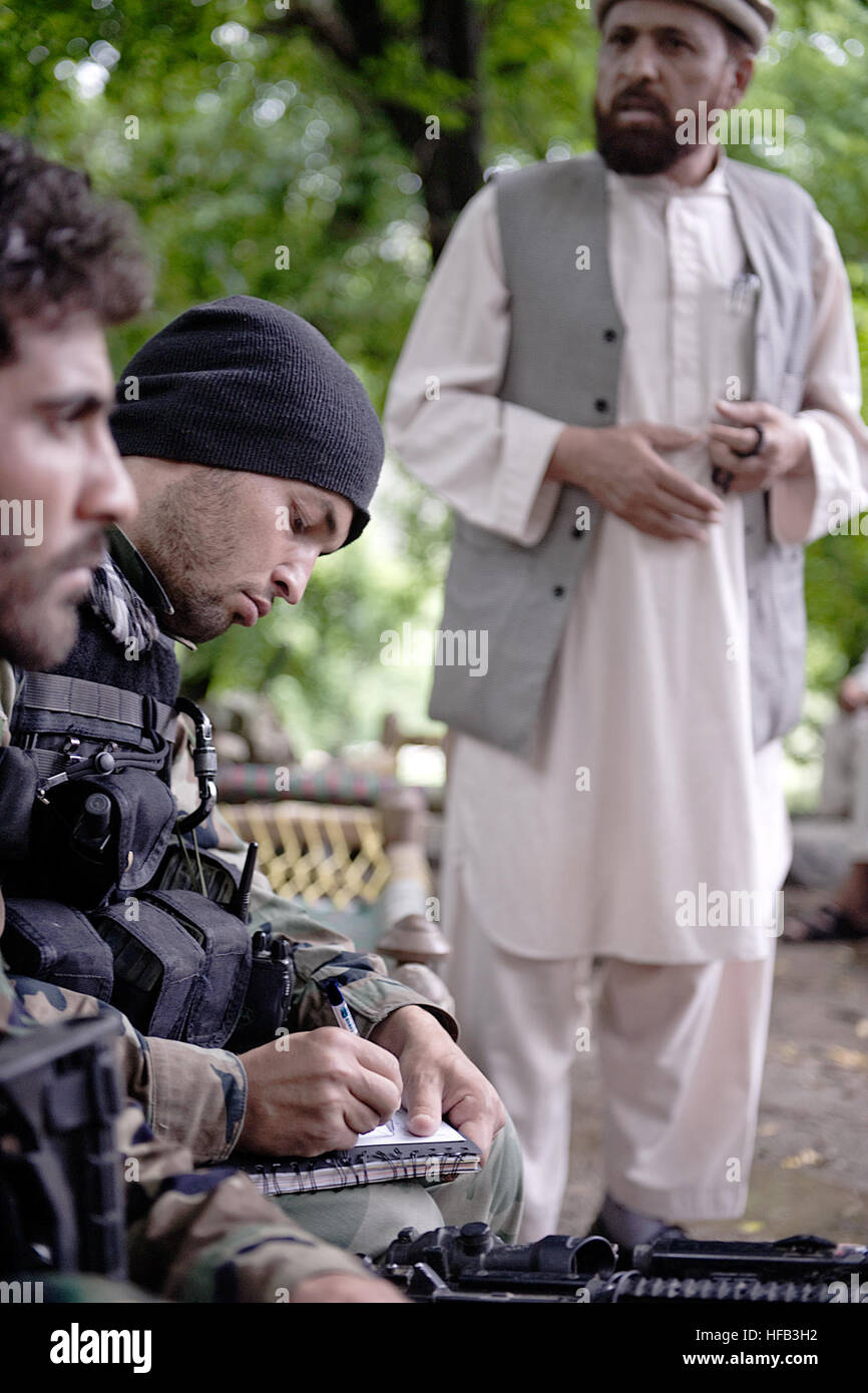 An Afghan National Army commando company commander takes notes during a shura in Kunar province, Afghanistan, April 28. Afghan National Police and district officials discussed the Afghan National Army commando mission in the valley and how it supports the Afghan Local Police mission. Commandos and coalition special operations forces searched the village for weapons caches and insurgent activity. Commando-led missions provide national security by encouraging local villagers to look to government forces for support rather than insurgents networks. Commando mission in Afghanistan 120428-N-BV659-2 Stock Photo